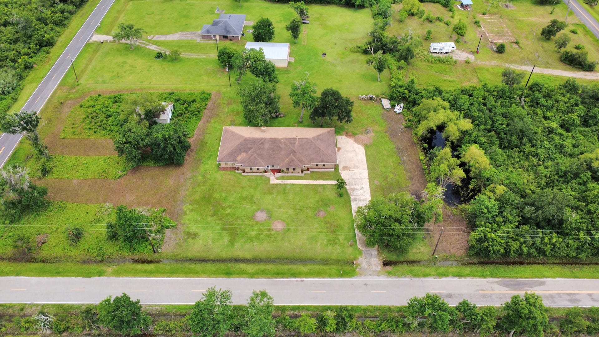 5241 County Road 819, Brazoria, TX 77422 In this stunning aerial view showcasing this property, you can appreciate the greenery surrounding the house.