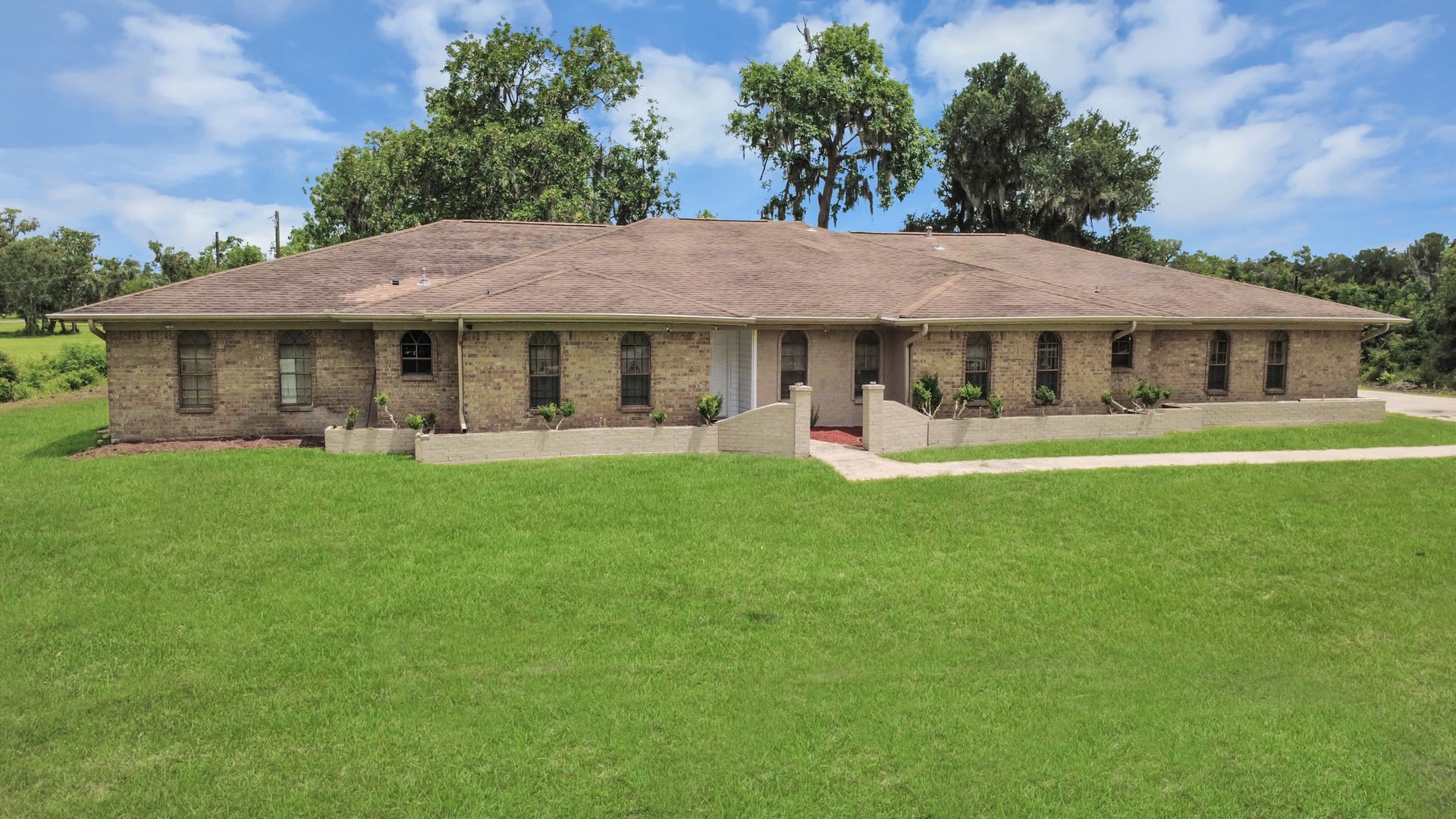 5241 County Road 819, Brazoria, TX 77422 Grandiose view of the house and the well-maintained yard. You can even feel the fresh air.