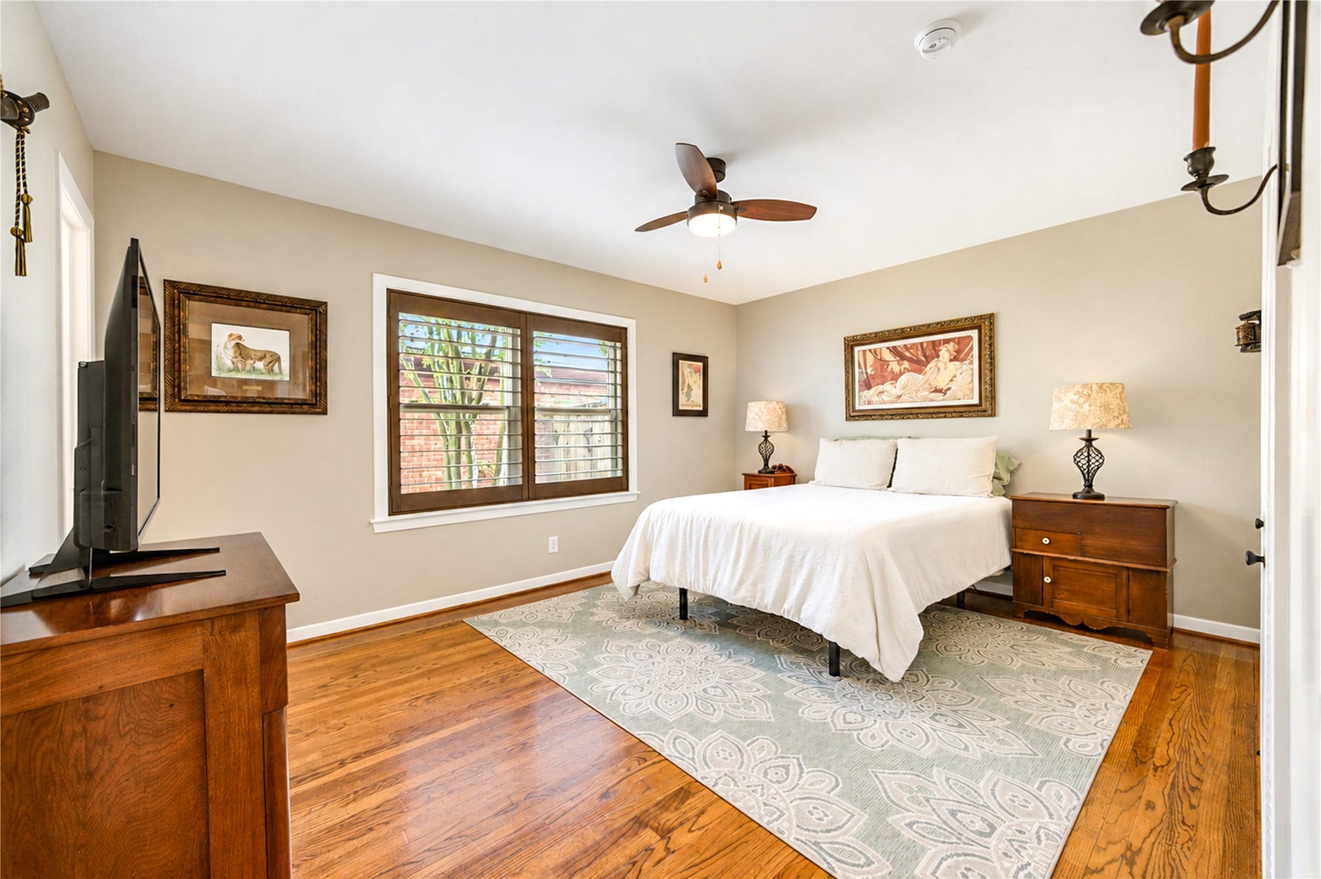6211 Grovewood Lane, Houston, TX 77008 Plantation shutters and hardwood flooring continue in this bedroom, where large windows bring in natural light.