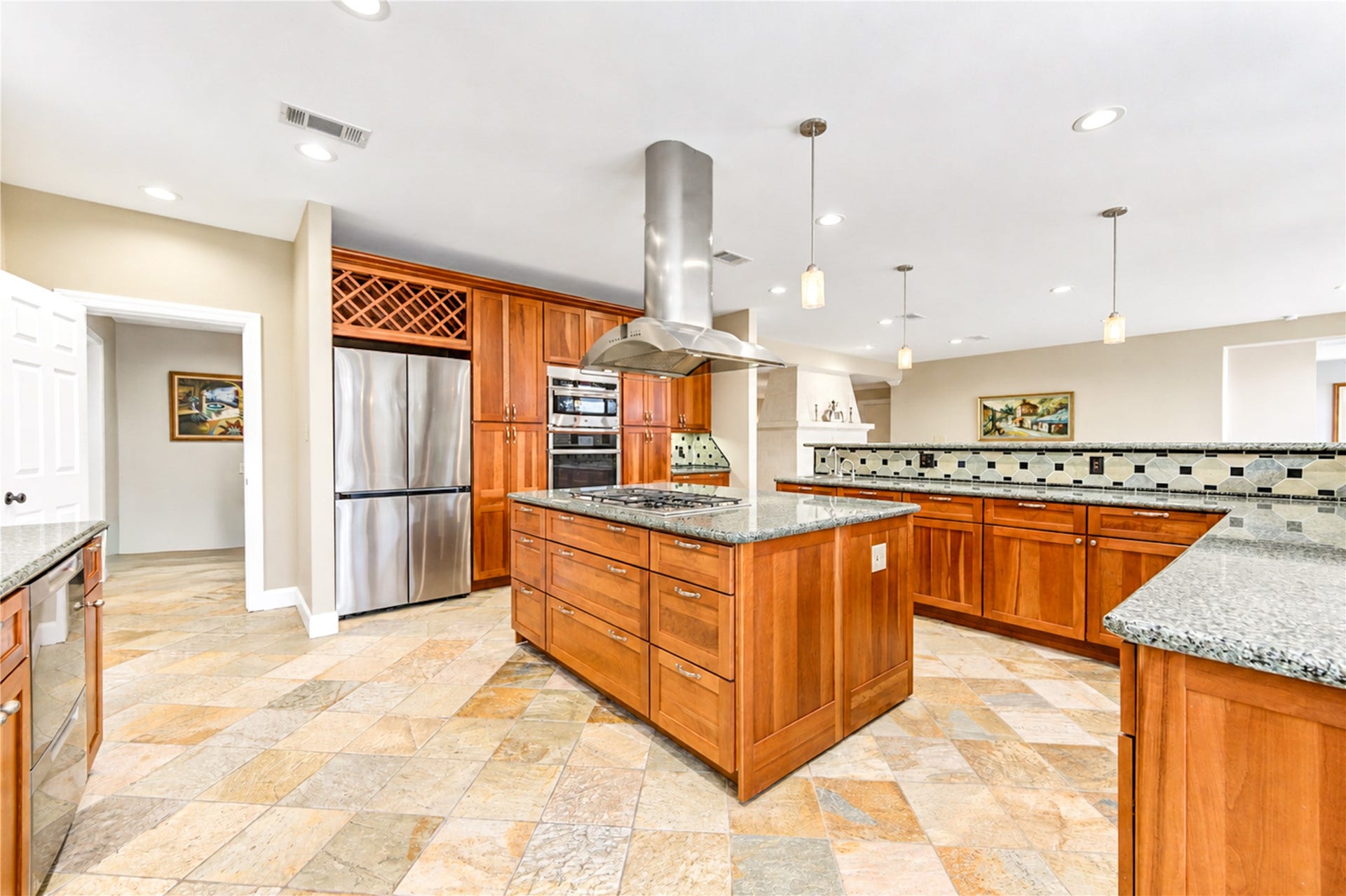6211 Grovewood Lane, Houston, TX 77008 The kitchen opens to the family room, with built-in double ovens, a wine rack and a gas cooktop island beneath the vent hood.