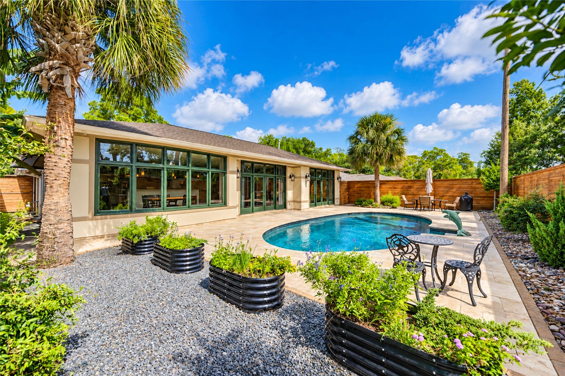 6211 Grovewood Lane, Houston, TX 77008 Expansive glass opens the rear of the home to the pool, the travertine terrace and raised garden planters.