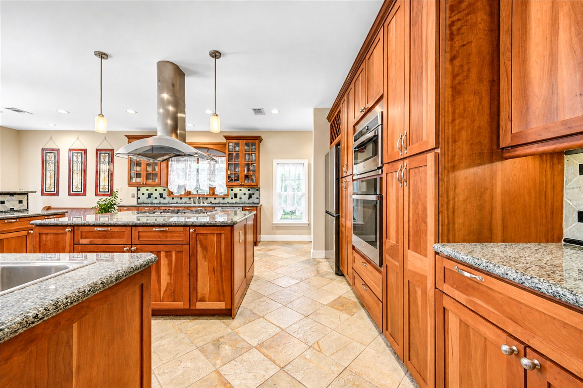 6211 Grovewood Lane, Houston, TX 77008 Stone flooring, a chandelier and a corner of wood-framed windows make the breakfast nook a bright setting beside the pool.