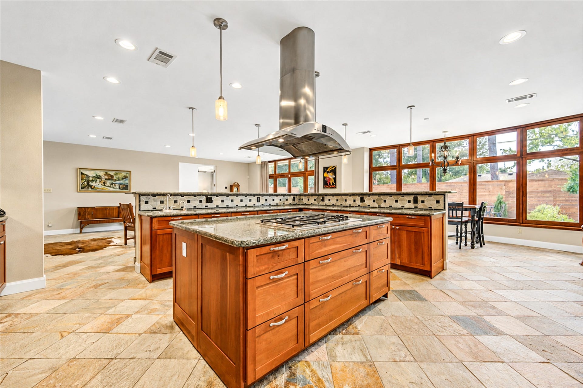 6211 Grovewood Lane, Houston, TX 77008 Two generous islands, granite countertops, rich wood cabinetry and a statement vent hood distinguish the light-filled kitchen.