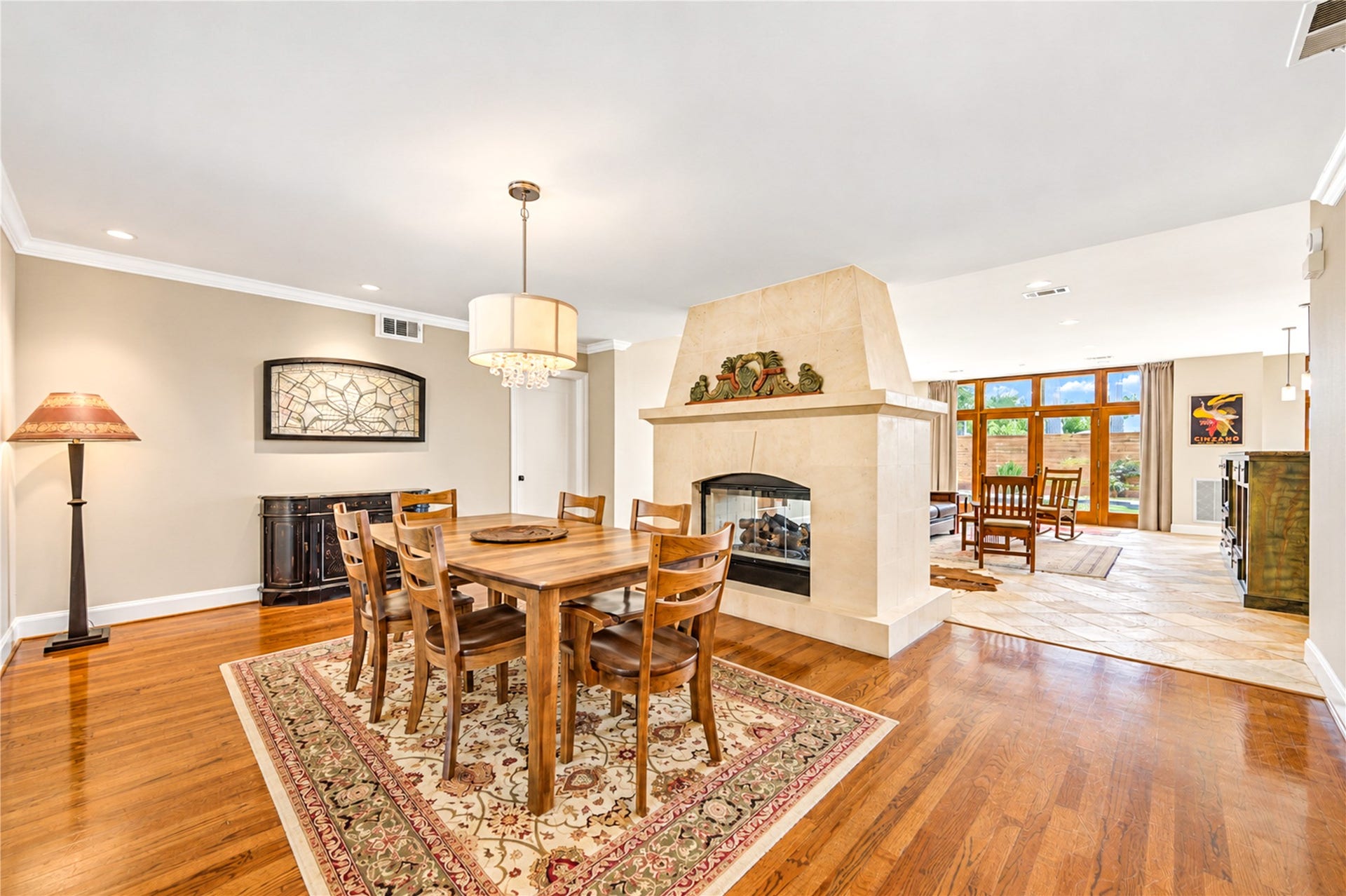 6211 Grovewood Lane, Houston, TX 77008 A two-sided fireplace connects the dining and family rooms, while expansive windows fill the spaces with natural light and enhance the home's open design.