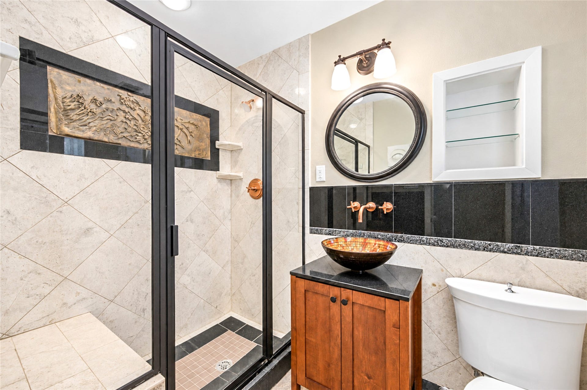 6211 Grovewood Lane, Houston, TX 77008 A framed glass shower with large-format tile, a granite accent band and a vessel sink on a wood vanity create a refined bath.