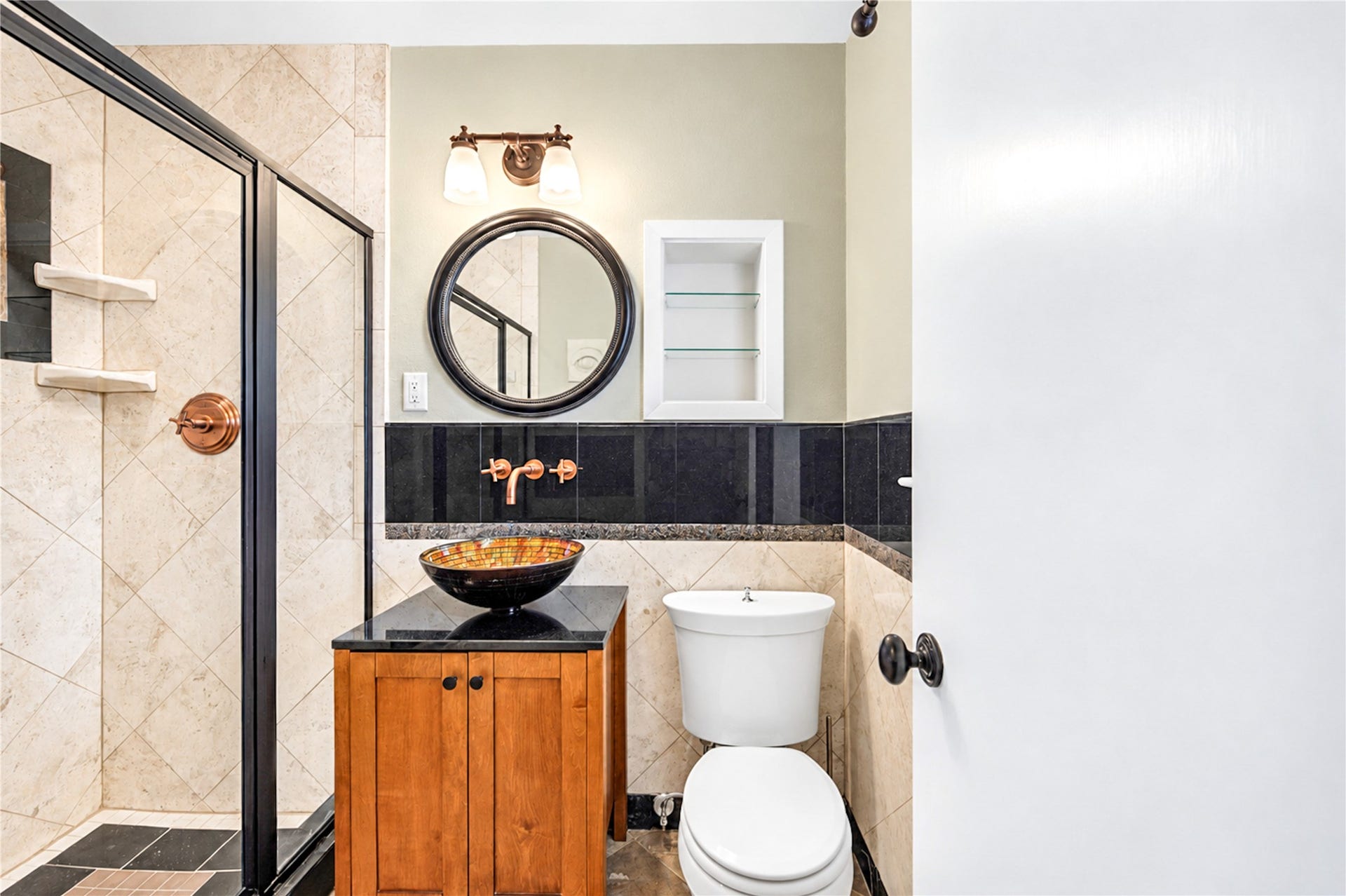 6211 Grovewood Lane, Houston, TX 77008 A vessel sink, black granite backsplash, round mirror and recessed shelving give this bath a distinctive, finished character.