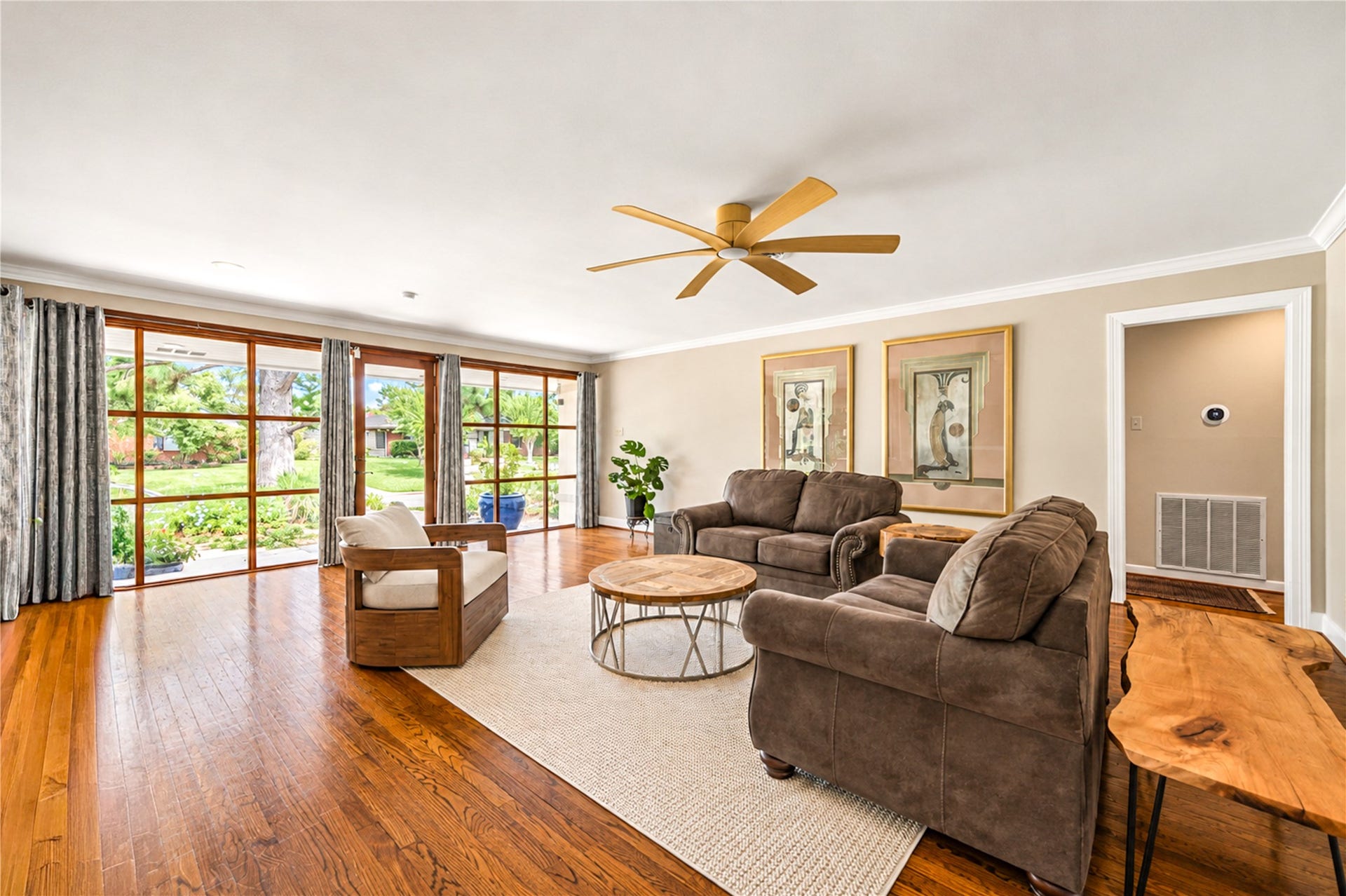 6211 Grovewood Lane, Houston, TX 77008 Hardwood flooring extends across the generous living room, where wood-framed glass opens the space to the garden.
