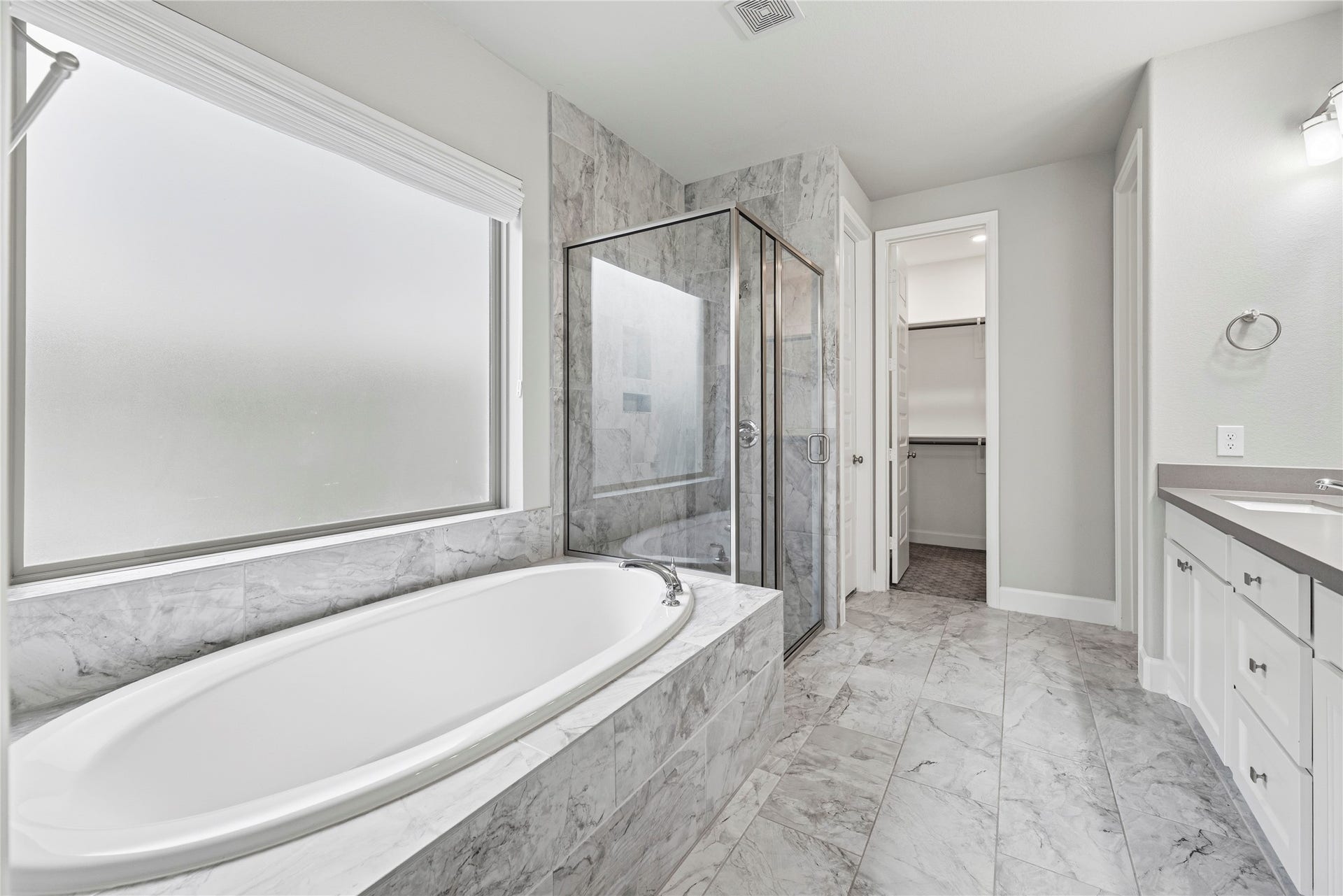 9511 Shaded Tree Drive, Missouri City, TX 77459 Primary en-suite with a double sink vanity, framed mirror, large walk-in shower and soaking tub.