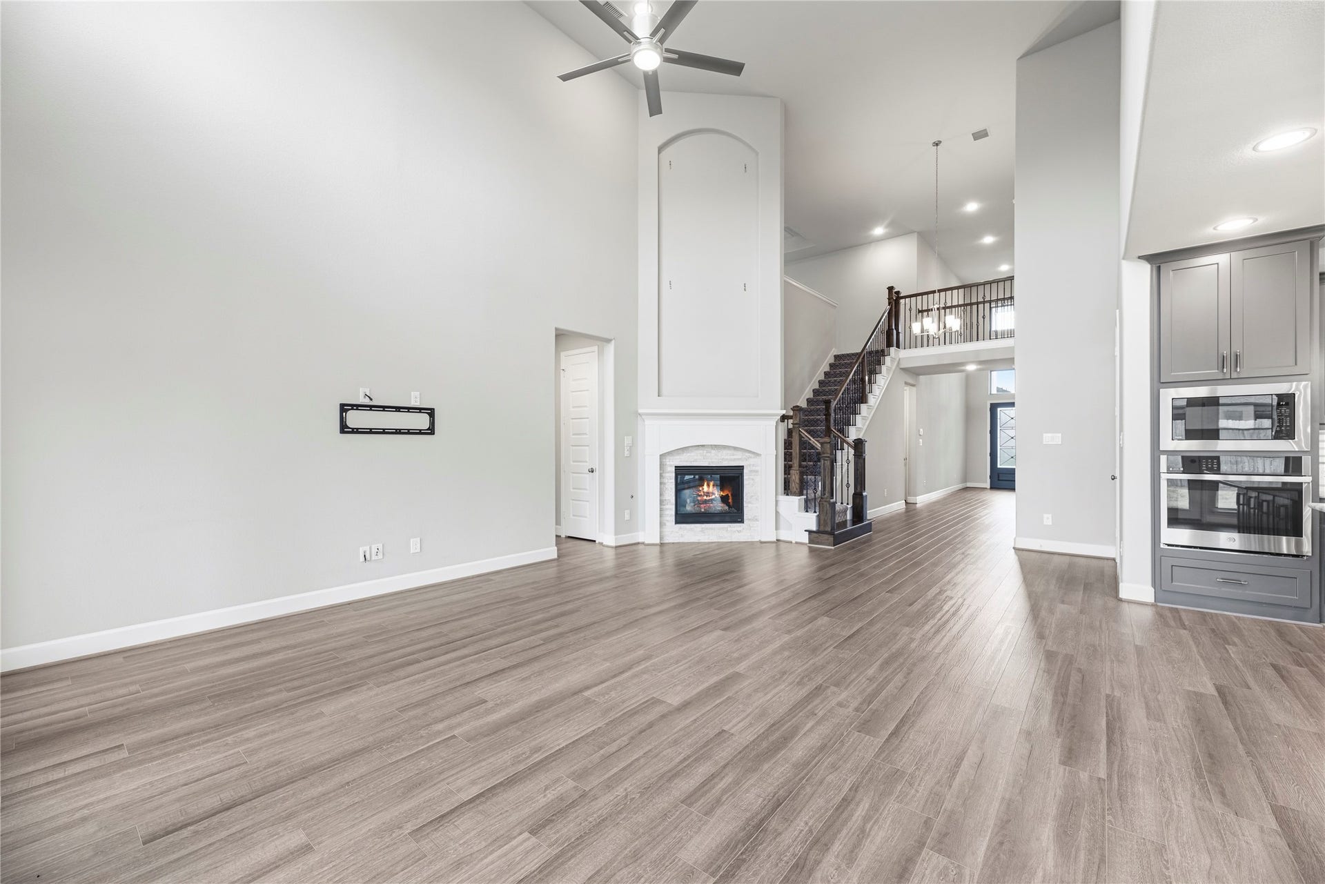 9511 Shaded Tree Drive, Missouri City, TX 77459 Grand living room with soaring ceilings, upgraded fireplace, sleek floors and neutral paint.