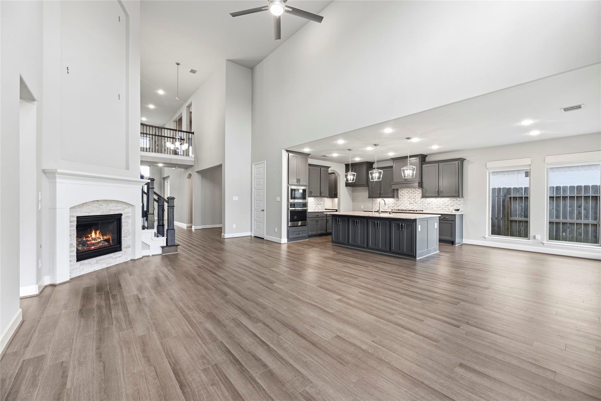 9511 Shaded Tree Drive, Missouri City, TX 77459 Grand living room with soaring ceilings, upgraded fireplace, sleek floors and neutral paint.