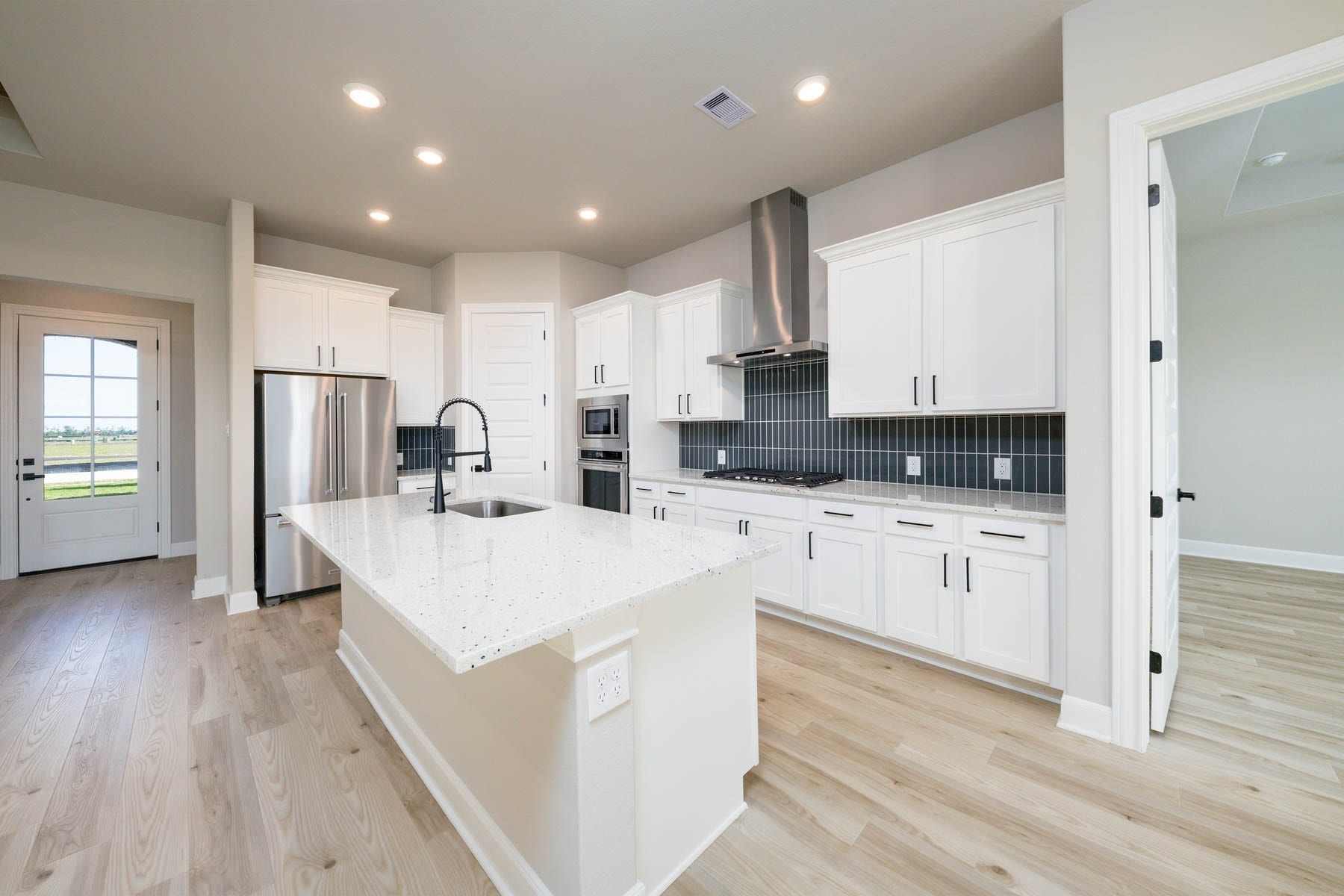 10506 Sutter Creek Drive, Iowa Colony, TX 77583 The kitchen island serves as a multifunctional hub, providing a seamless transition between the kitchen and family room, allowing for easy interaction and socializing while cooking or entertaining.
