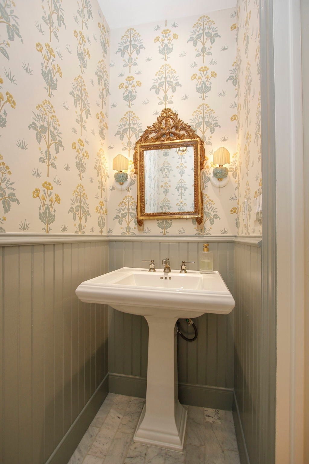 8515 Tranquil Park Drive, Spring, TX 77379 Here's one of the stylish half bathrooms, featuring a brand-new sink, toilet, elegant designer wallpaper, and luxurious Carrara marble floors.