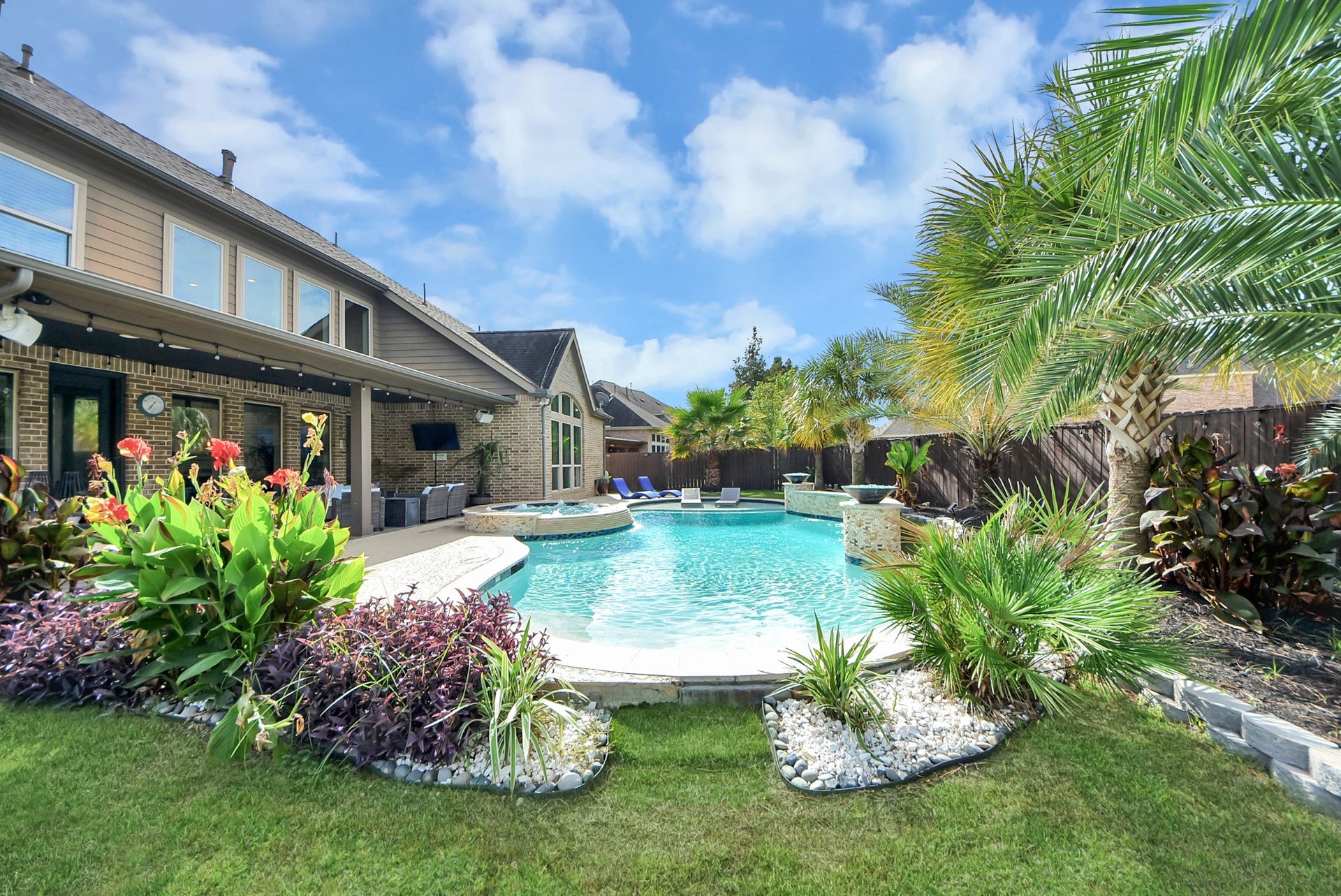9723 Painted Stone Court, Cypress, TX 77433 Dive into luxury with a stunning 2021 pool featuring a beach entry, attached spa, smart lighting, fountains, and two gas fire bowls for an elegant ambiance.