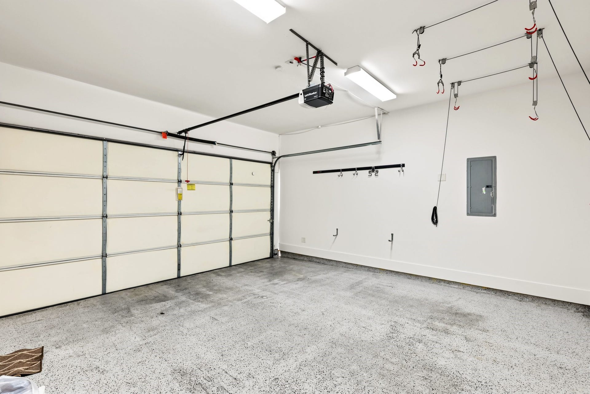 Enjoy the everyday convenience of a private, attached two-car garage equipped with an automatic door opener. Durable speckled epoxy flooring and a bright, well-lit interior create an impeccably clean, functional space for secure parking, extra storage, and weekend projects.