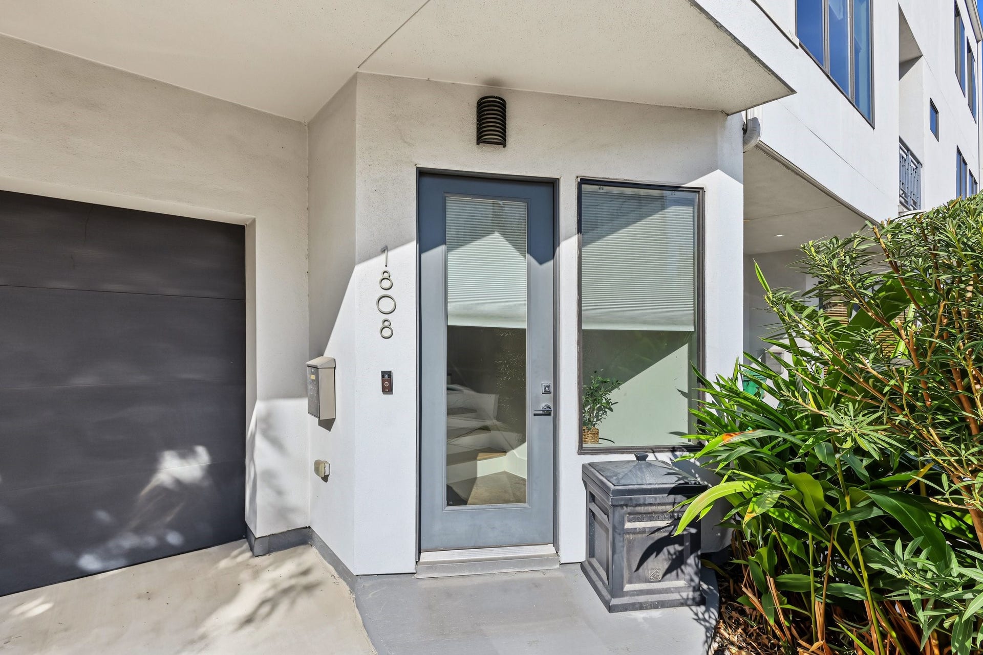 The propertys curb appeal is completed by intentional exterior landscaping and perimeter details, including a rich, horizontal-slat wooden privacy fence enclosing the side yard, a rock-landscaped bed anchored by a mature shade tree, and established ornamental trees and green shrubbery framing the front entrance.