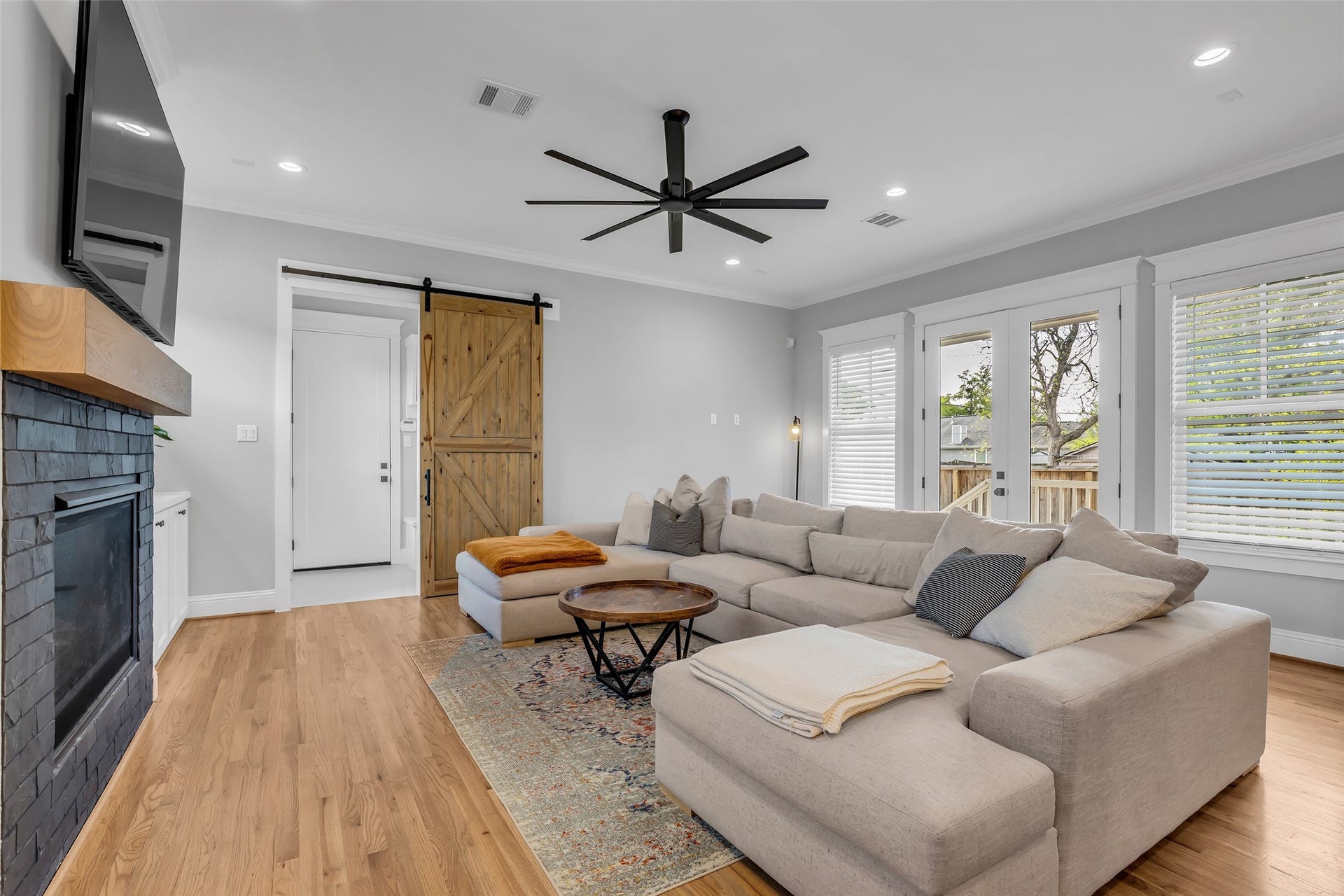 800 Walton Street, Houston, TX 77009 This view of the living room highlights the glass door leading outside, as well as a door that provides access to the hallway connecting to the garage.