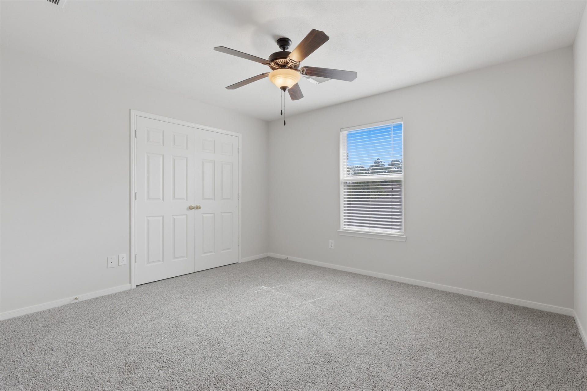 Spacious secondary bedroom featuring fresh neutral paint, brand new carper, bright natural light, and plenty of space for your furnishings.