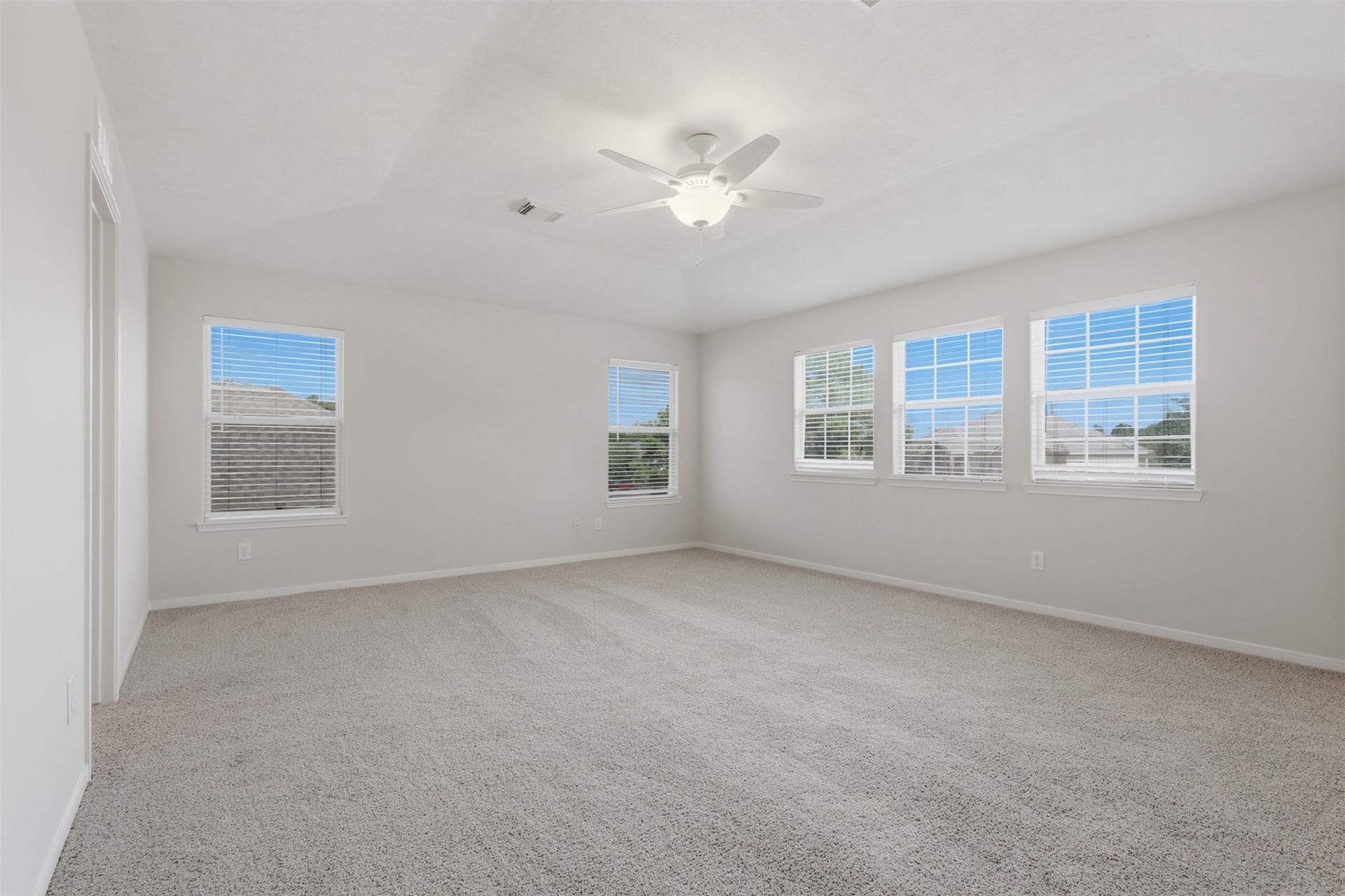 This massive primary bedroom on the second floor boasts five large windows that fill the space with natural light, brand-new carpet, and fresh paint throughout.