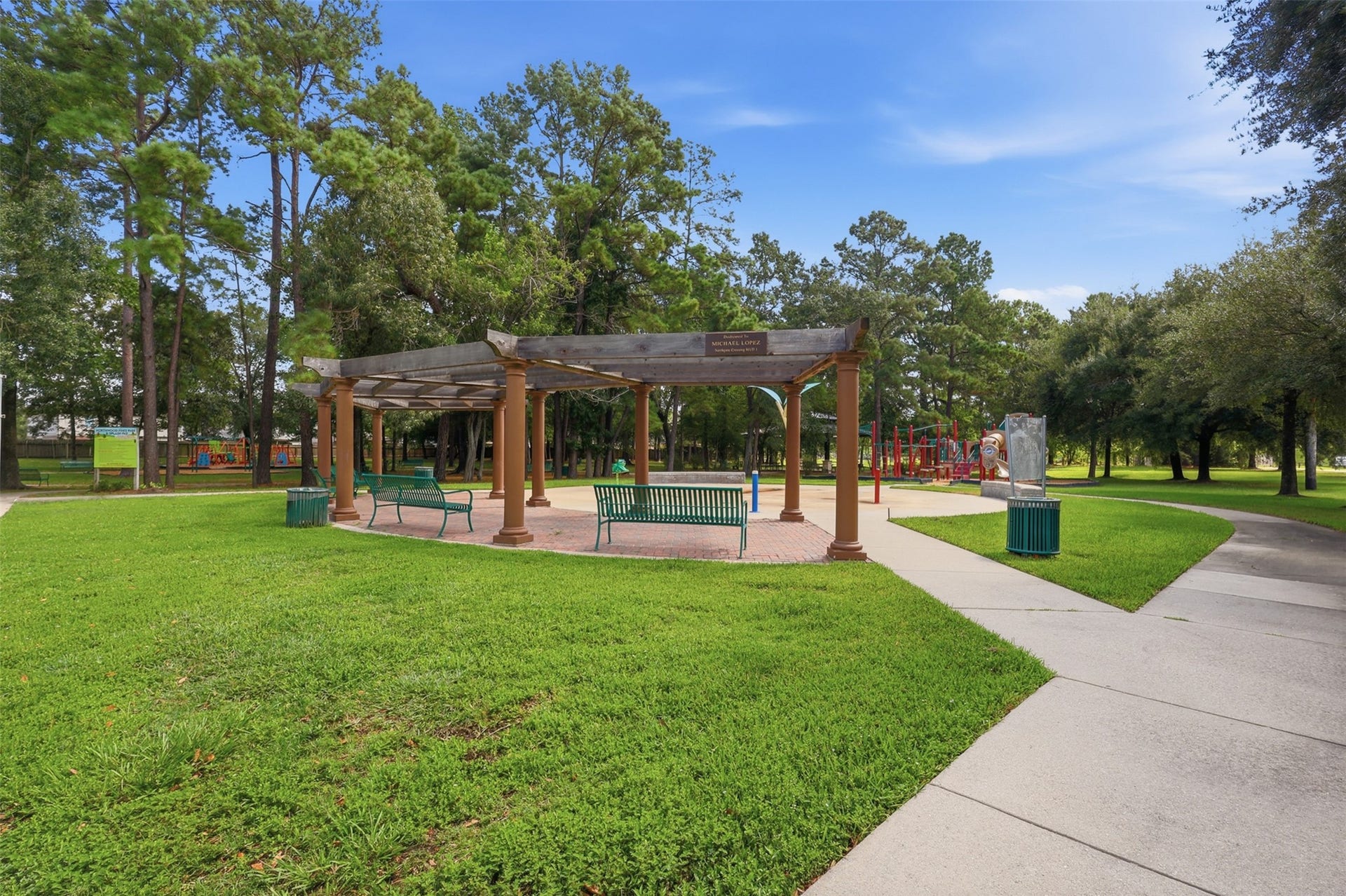 Great neighborhood gathering space! Features concrete walking paths, a large shaded pavilion with benches, and nearby play amenities for sunny Texas days.