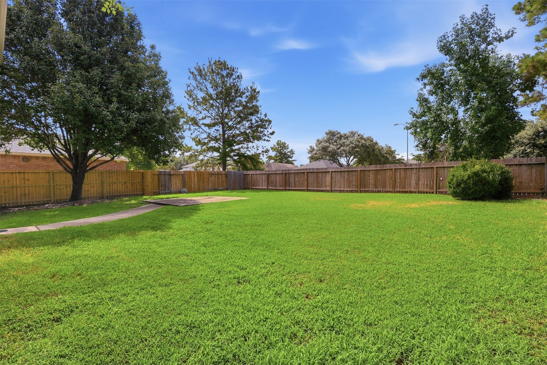 Spacious fully-fenced backyard with lush grass and beautiful shade treesyour own private outdoor oasis!