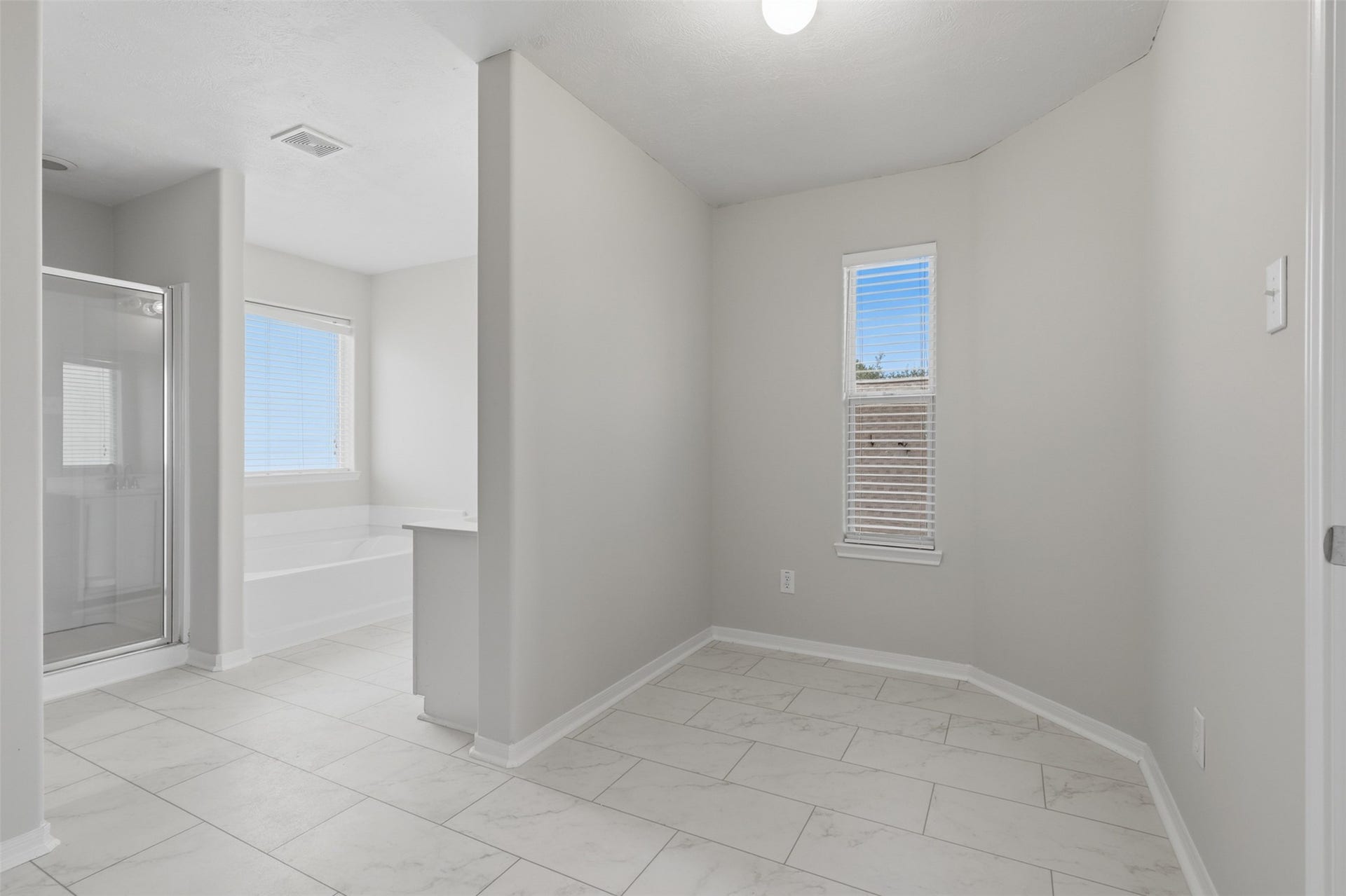 Spacious primary en-suite bathroom featuring a welcoming entry landingperfect for a custom vanity, dressing station, or get-ready space.