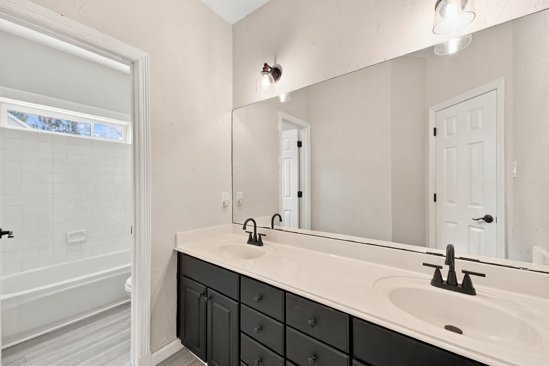 1065 Heritage Lane, Conroe, TX 77304 This secondary full bath is located upstairs and is shared by the three secondary bedrooms. Notice the two sinks and large vanity! The updated lighting and hardware are so pretty too!