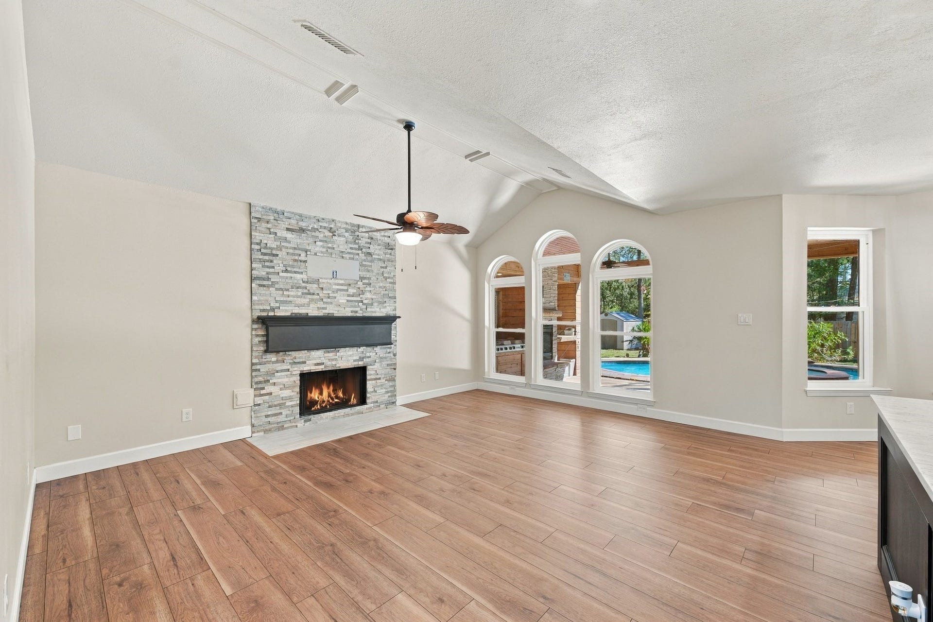 1065 Heritage Lane, Conroe, TX 77304 The large living room which is open to the kitchen and living room has a beautifully updated stacked stone fireplace with gas logs, a recently replaced ceiling fan and updated flooring.