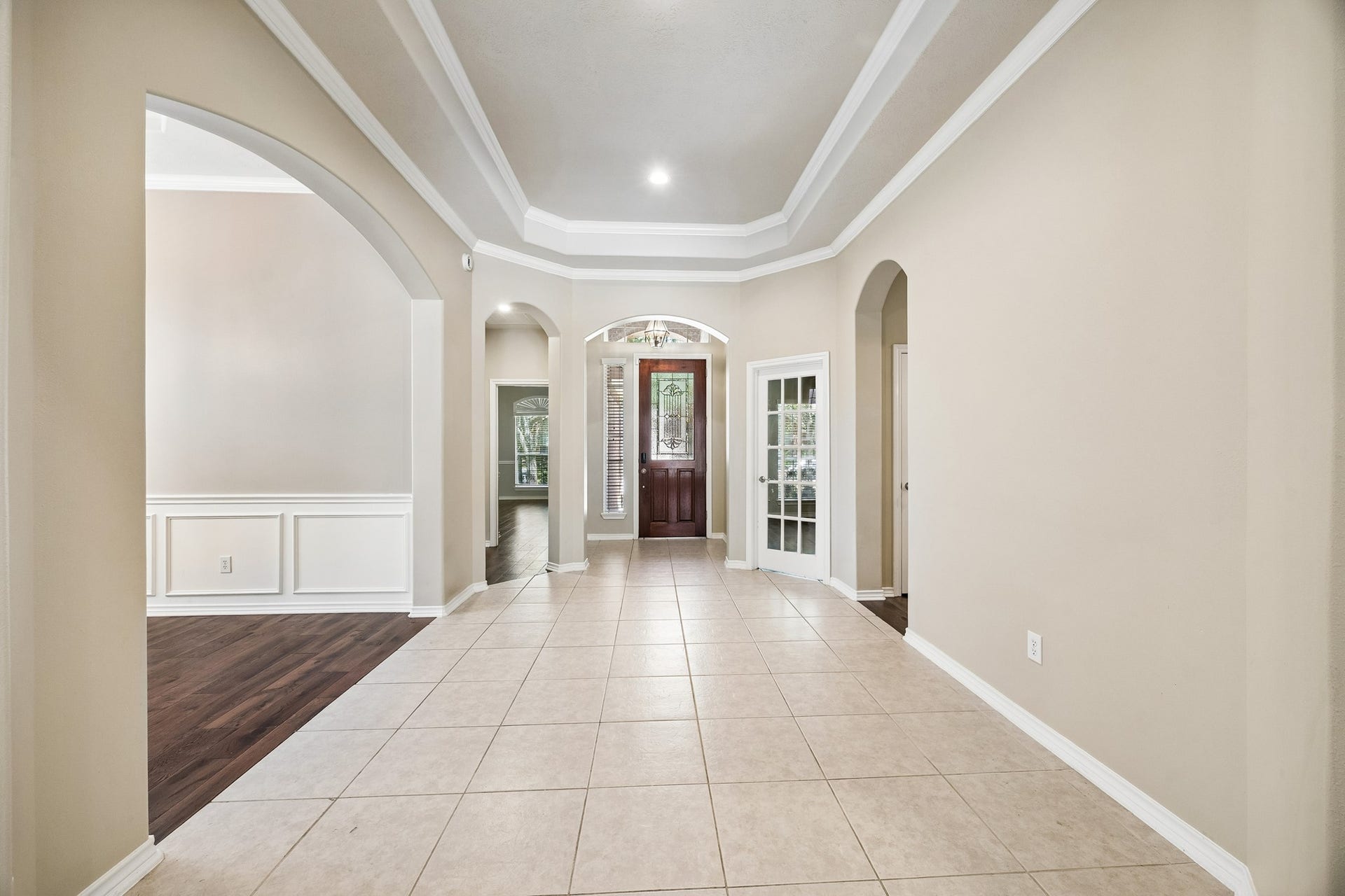 A warm and welcoming entry sets the tone with beautiful engineered hardwood flooring, fresh neutral paint, updated lighting, and elegant architectural details that carry throughout this spacious one-story home.