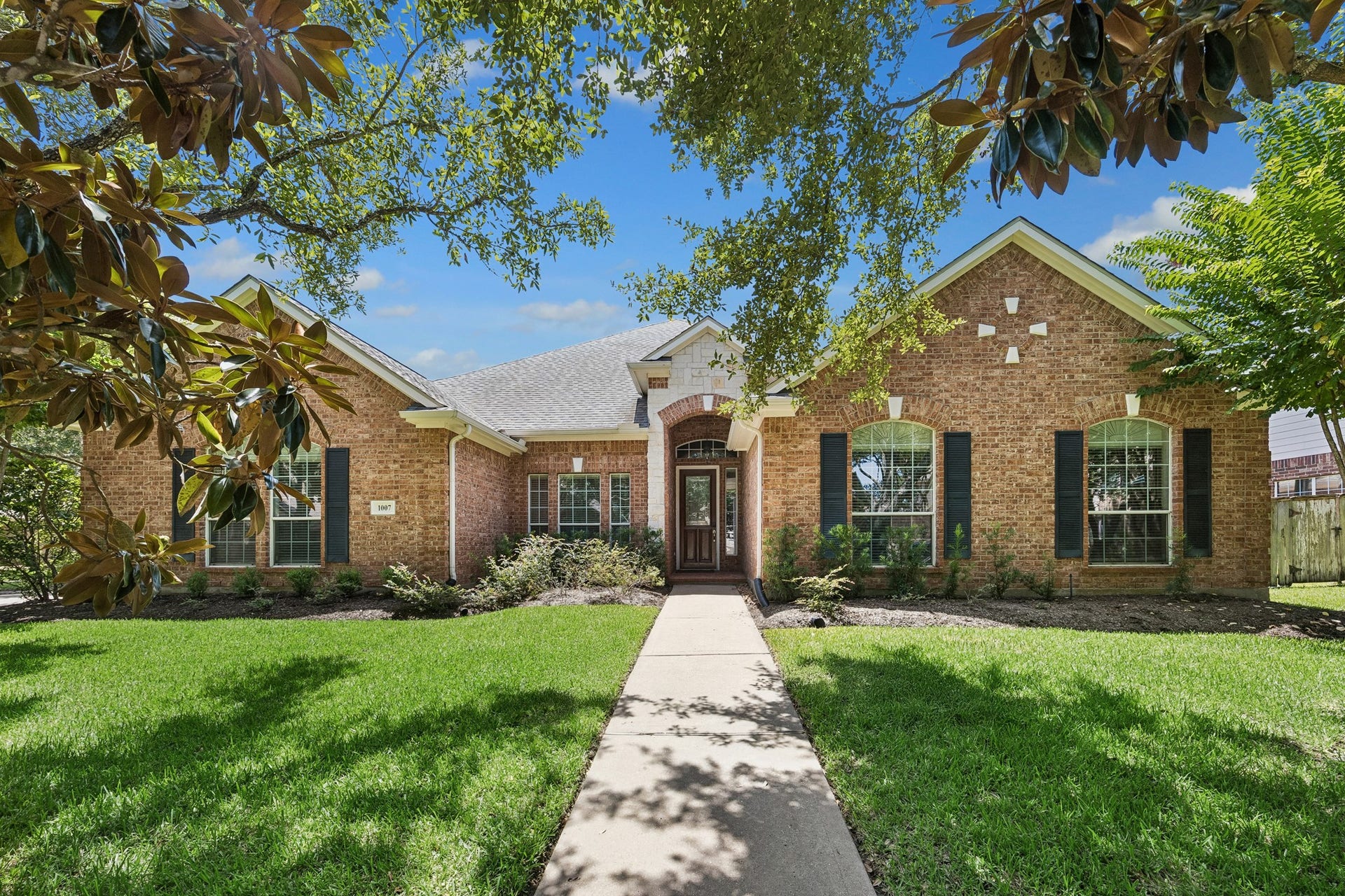 Beautiful curb appeal welcomes you home with mature shade trees, lush landscaping, and an inviting walkway leading to the charming one-story brick exterior, all situated on an oversized 10,322 sq ft lot in a desirable Katy location.