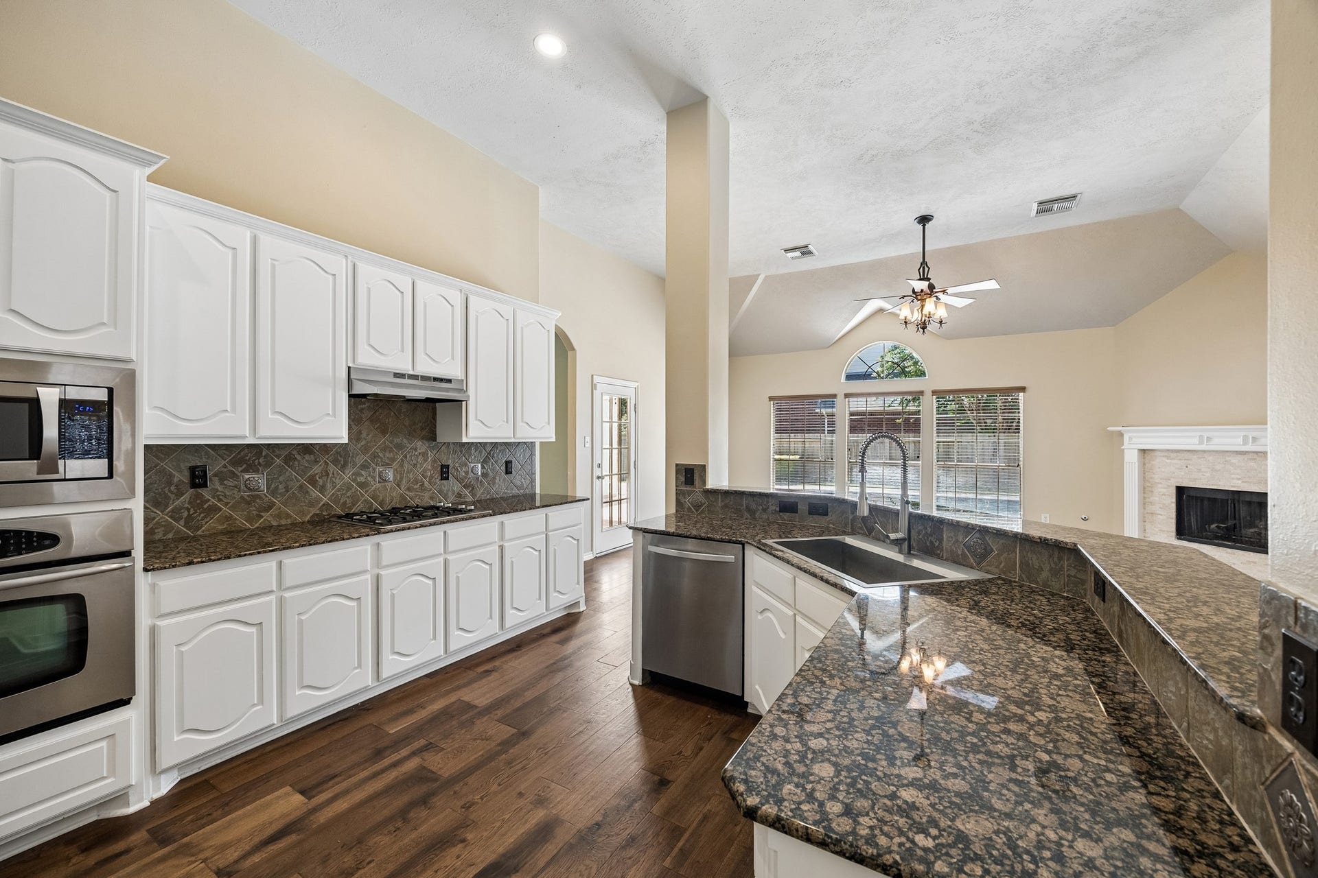 Designed with both function and style in mind, the kitchen offers expansive granite countertops, abundant cabinetry, stainless steel appliances, and a spacious breakfast bar perfect for casual dining, meal prep, or entertaining.