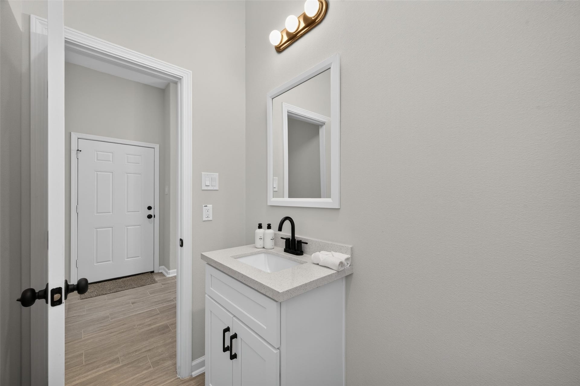 5915 Haight Street, #A, Houston, TX 77028 Elegant bathroom features a sleek vanity with a modern black faucet and ample storage. The space is illuminated by stylish lighting, enhancing its contemporary design.