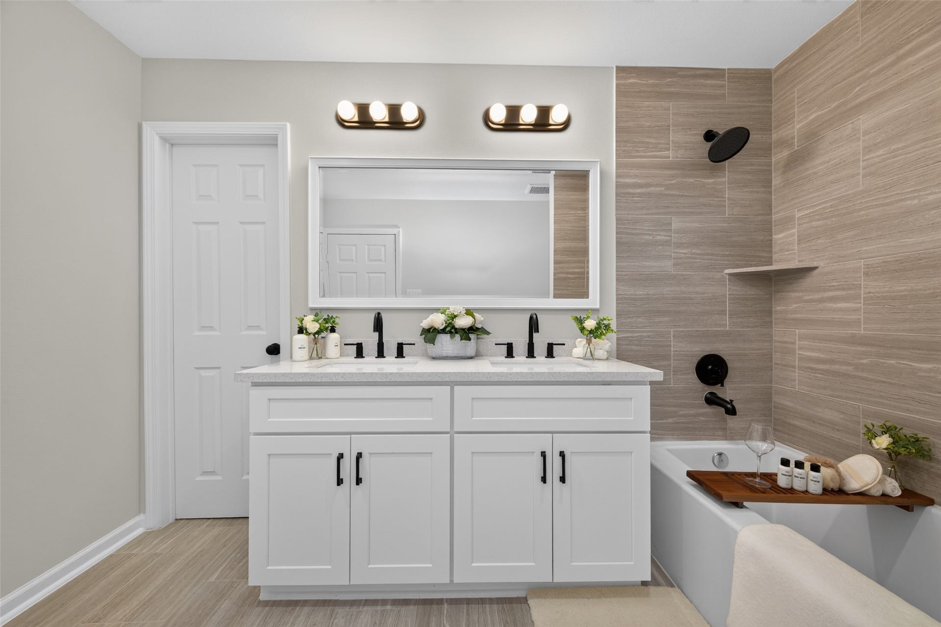 5915 Haight Street, #A, Houston, TX 77028 Stylish bathroom featuring a modern double vanity with sleek black fixtures, complemented by a chic tiled shower and tub combination, creating a serene and inviting space.