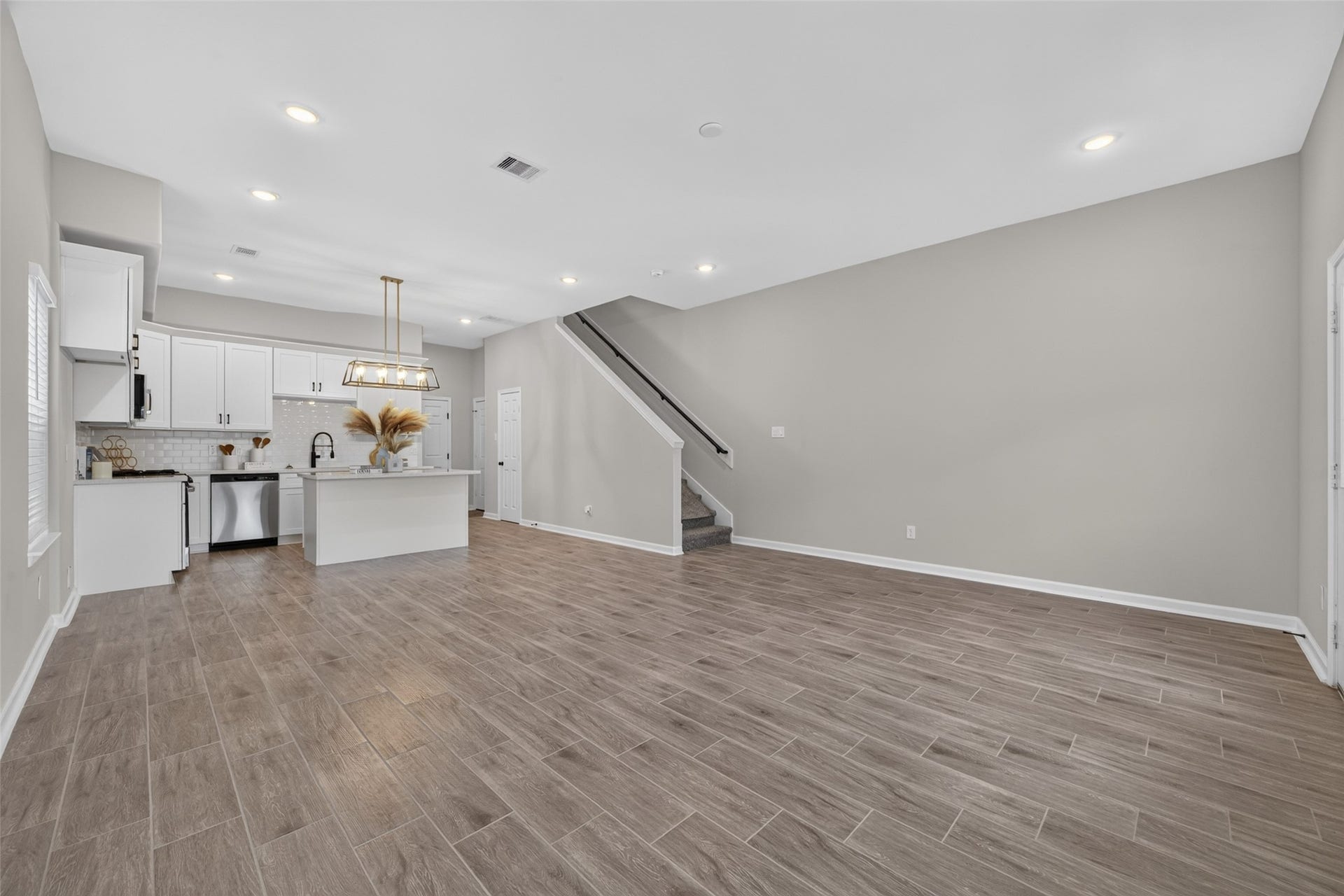 5915 Haight Street, #A, Houston, TX 77028 Spacious living area with elegant wood-look tile flooring, neutral walls.