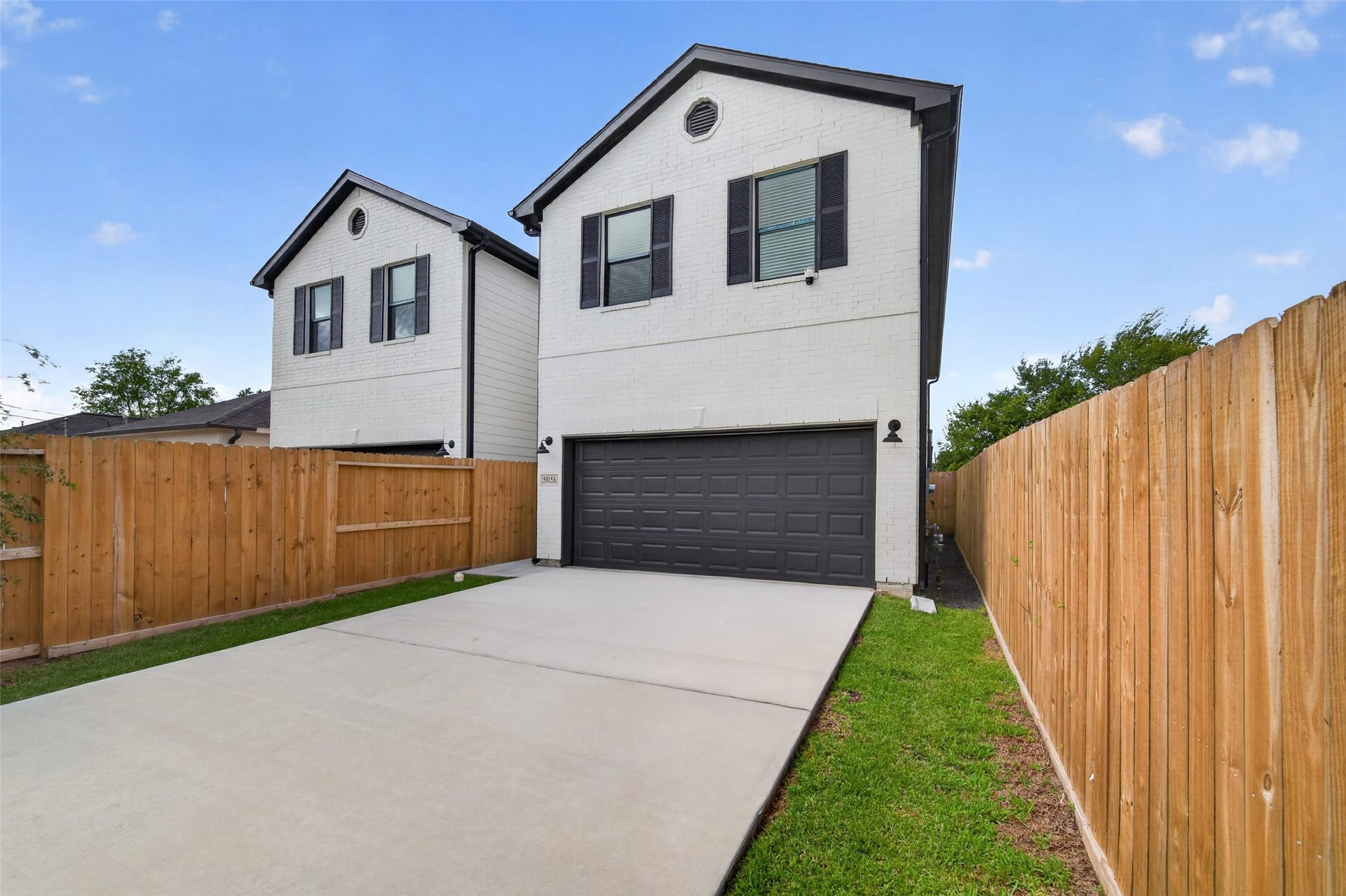 5915 Haight Street, #A, Houston, TX 77028 Modern home with clean lines and contrasting black accents, secured by a gated driveway, offer a stylish and private living environment.