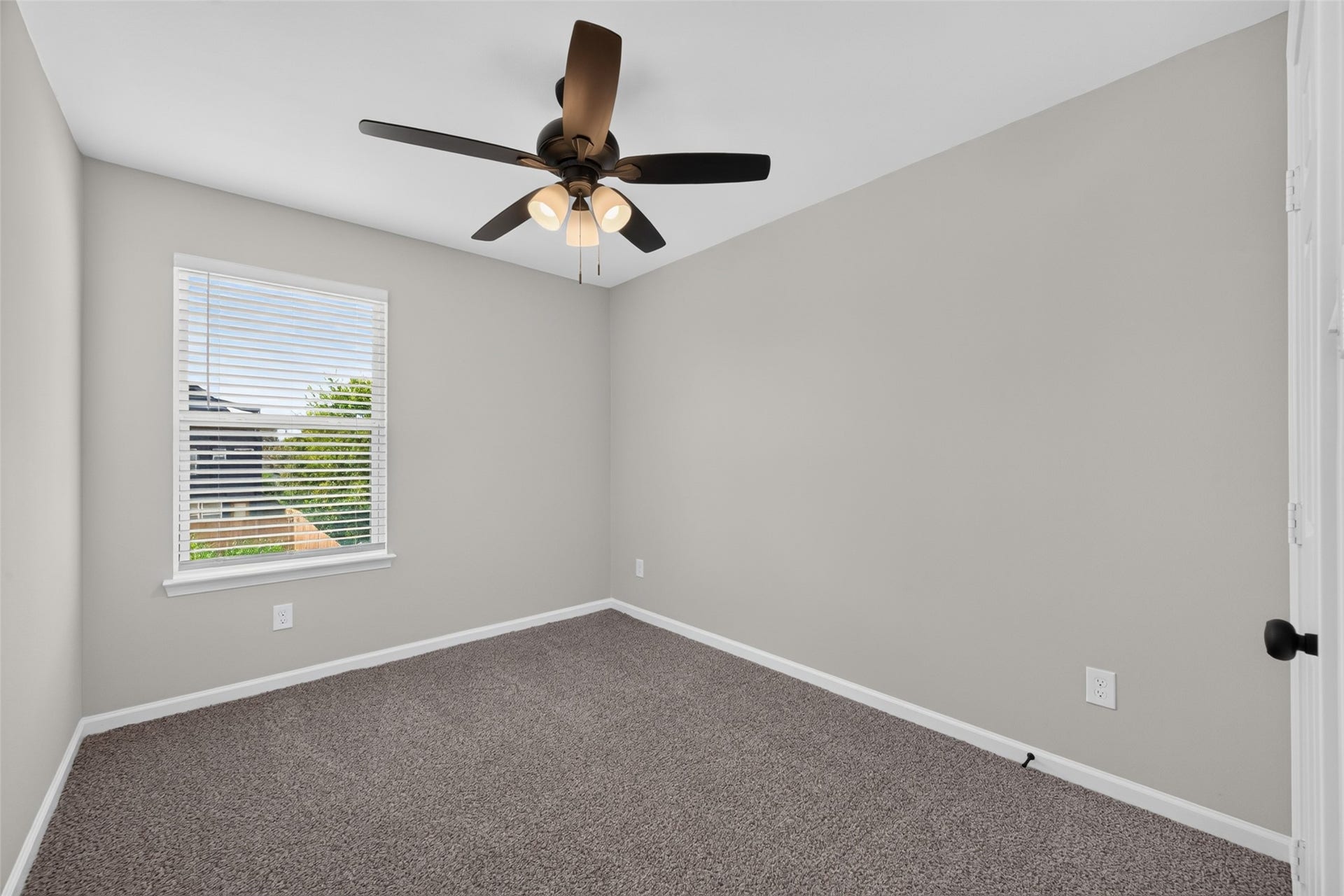 5915 Haight Street, #A, Houston, TX 77028 Cozy bedroom with plush carpeting, a modern ceiling fan, and a bright window offering natural light.