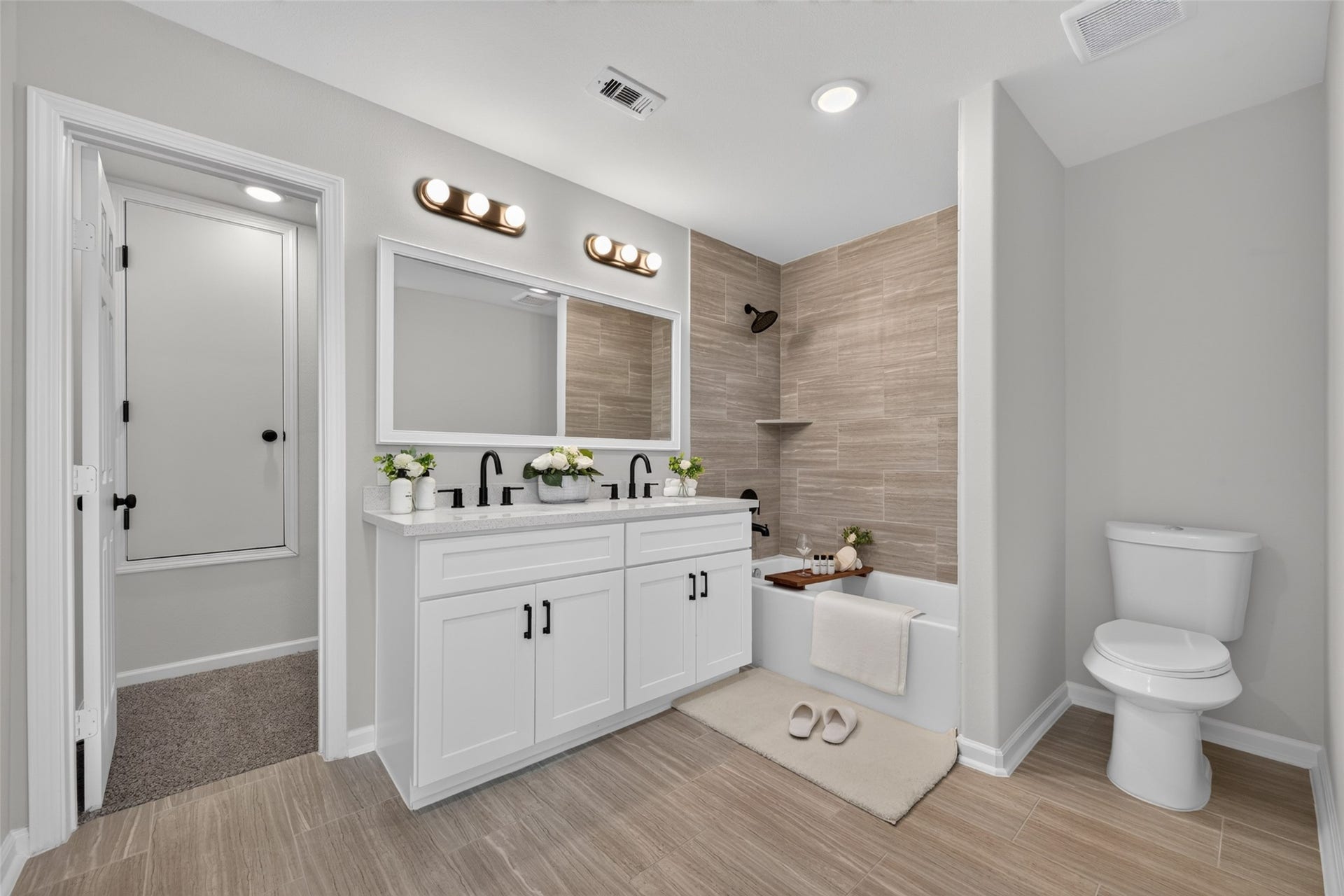 5915 Haight Street, #A, Houston, TX 77028 Elegant bathroom with a modern double vanity, stylish tile flooring, and a cozy bathtub accented by warm wood tiles.