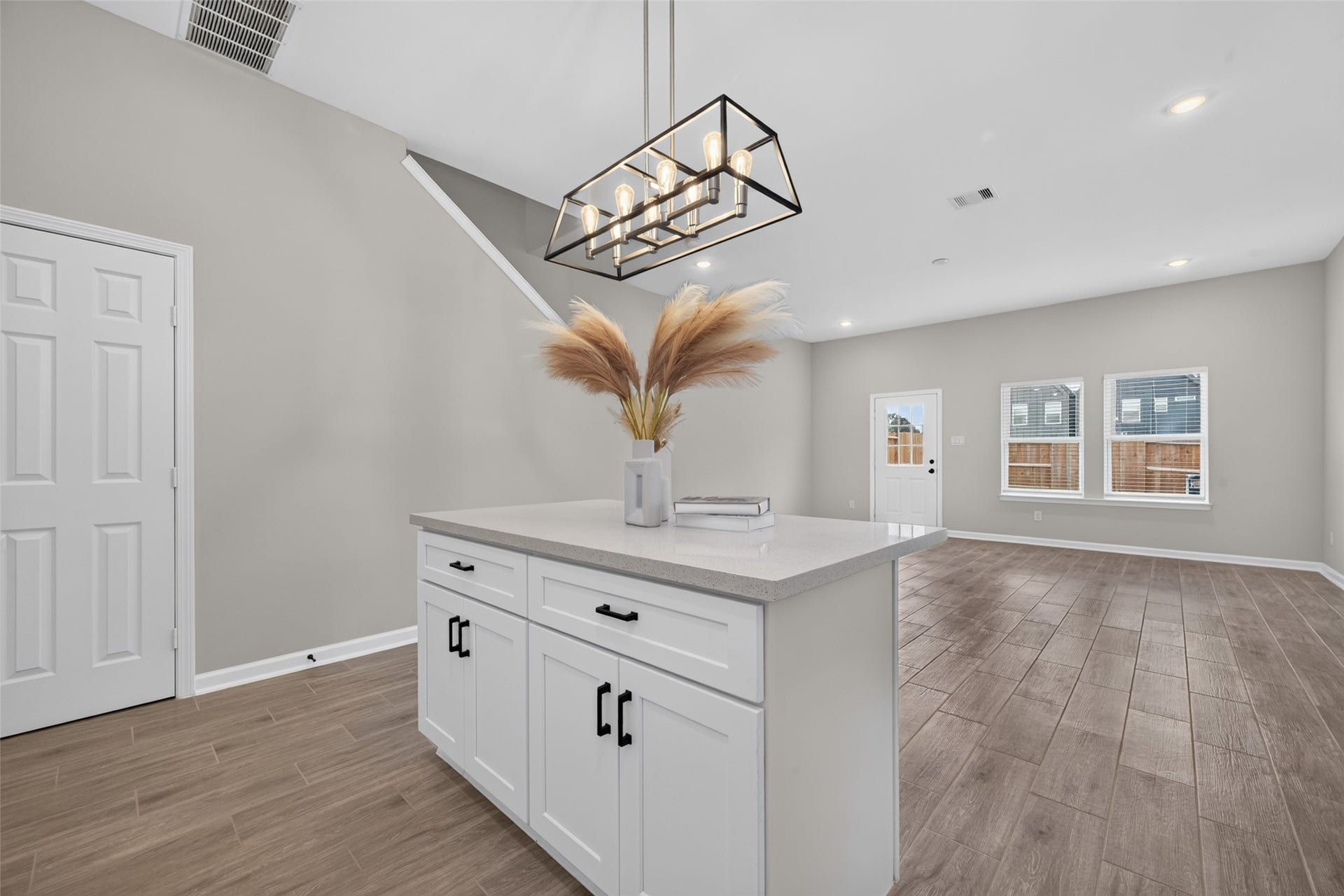 5915 Haight Street, #A, Houston, TX 77028 Bright and open living space with modern lighting, a central island with storage, and wood-look flooring, perfect for entertaining.