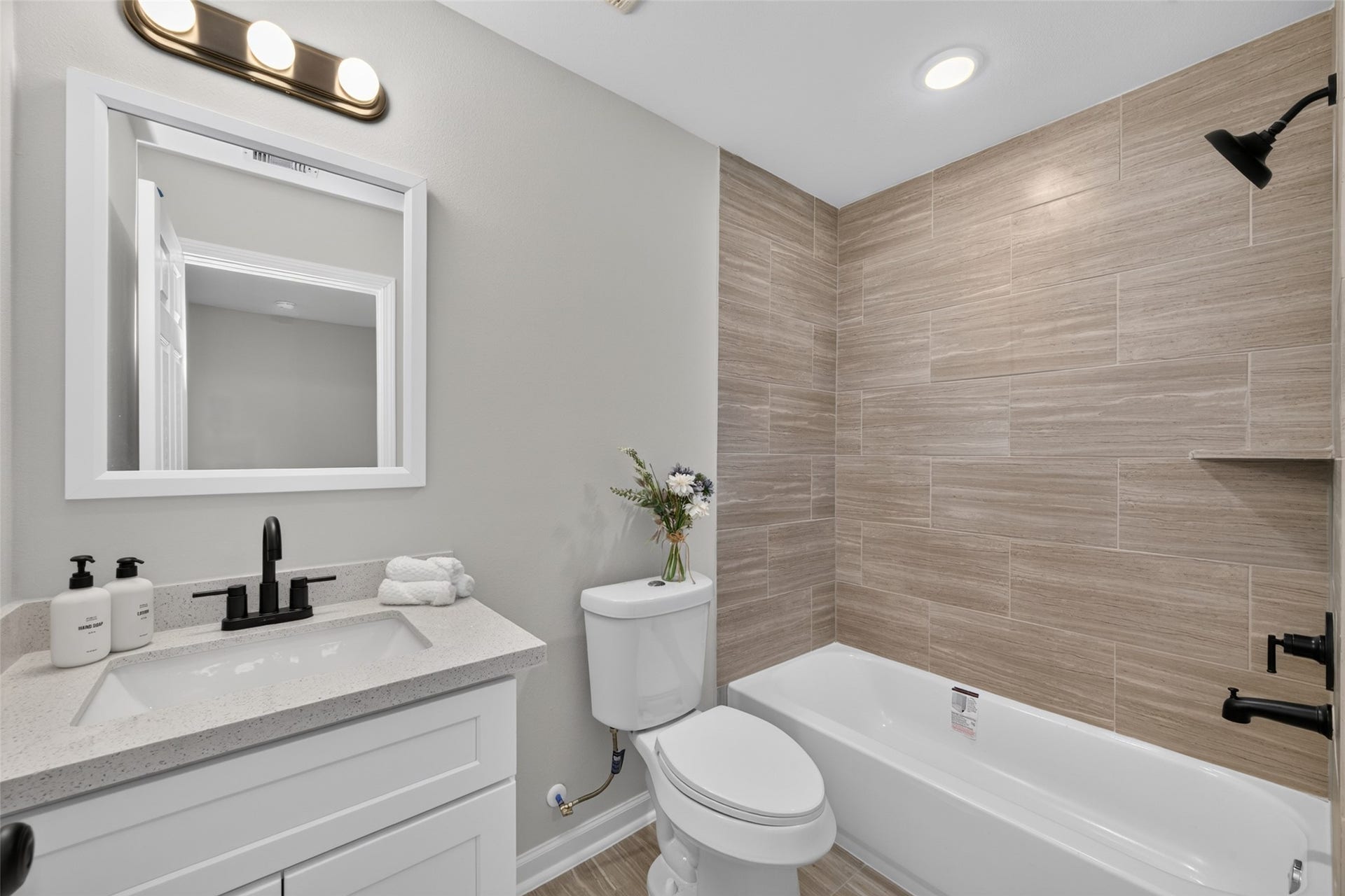 5915 Haight Street, #A, Houston, TX 77028 Modern bathroom with sleek fixtures, featuring a spacious vanity, elegant lighting, and a stylishly tiled shower-tub combination.