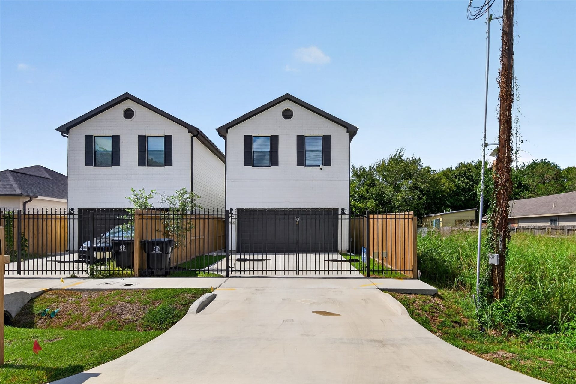 5915 Haight Street, #A, Houston, TX 77028 Modern home with clean lines and contrasting black accents, secured by a gated driveway, offer a stylish and private living environment.