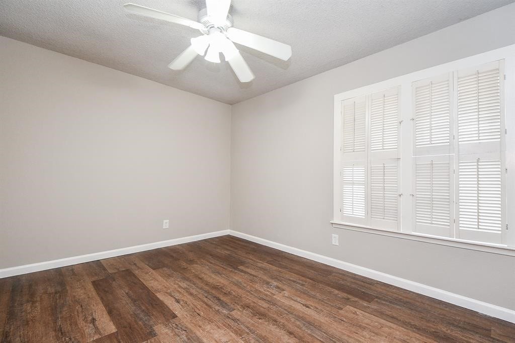 12569 Wellington Park Drive, Houston, TX 77072 This room features neutral walls, wood flooring, and a ceiling fan. A window with shutters provides natural light, creating a bright and inviting space.