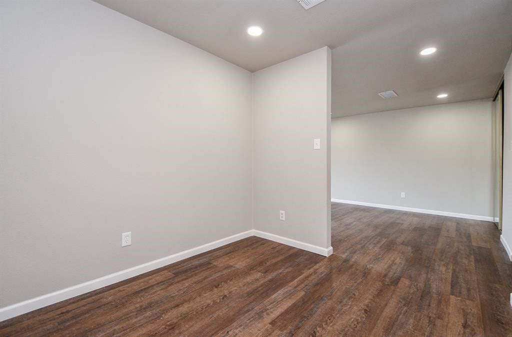 12569 Wellington Park Drive, Houston, TX 77072 This photo shows a bright, open hallway with wood flooring, recessed lighting, and neutral-colored walls, offering a modern, spacious feel.