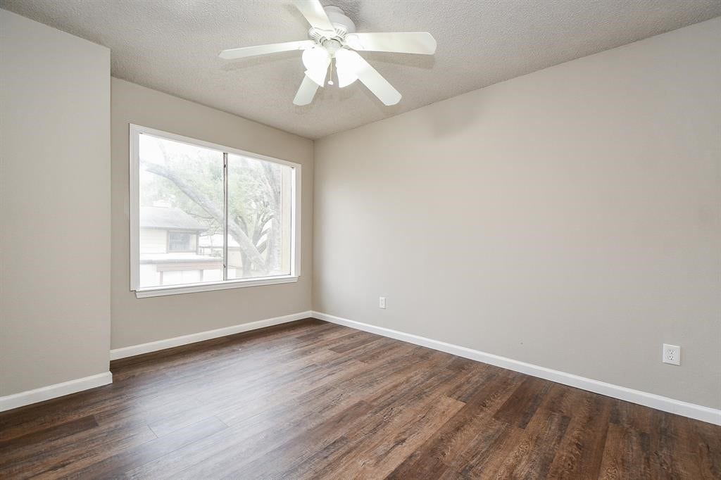 12569 Wellington Park Drive, Houston, TX 77072 Bright, airy room with a large window, ceiling fan, and wood flooring, perfect for a cozy bedroom or office space.