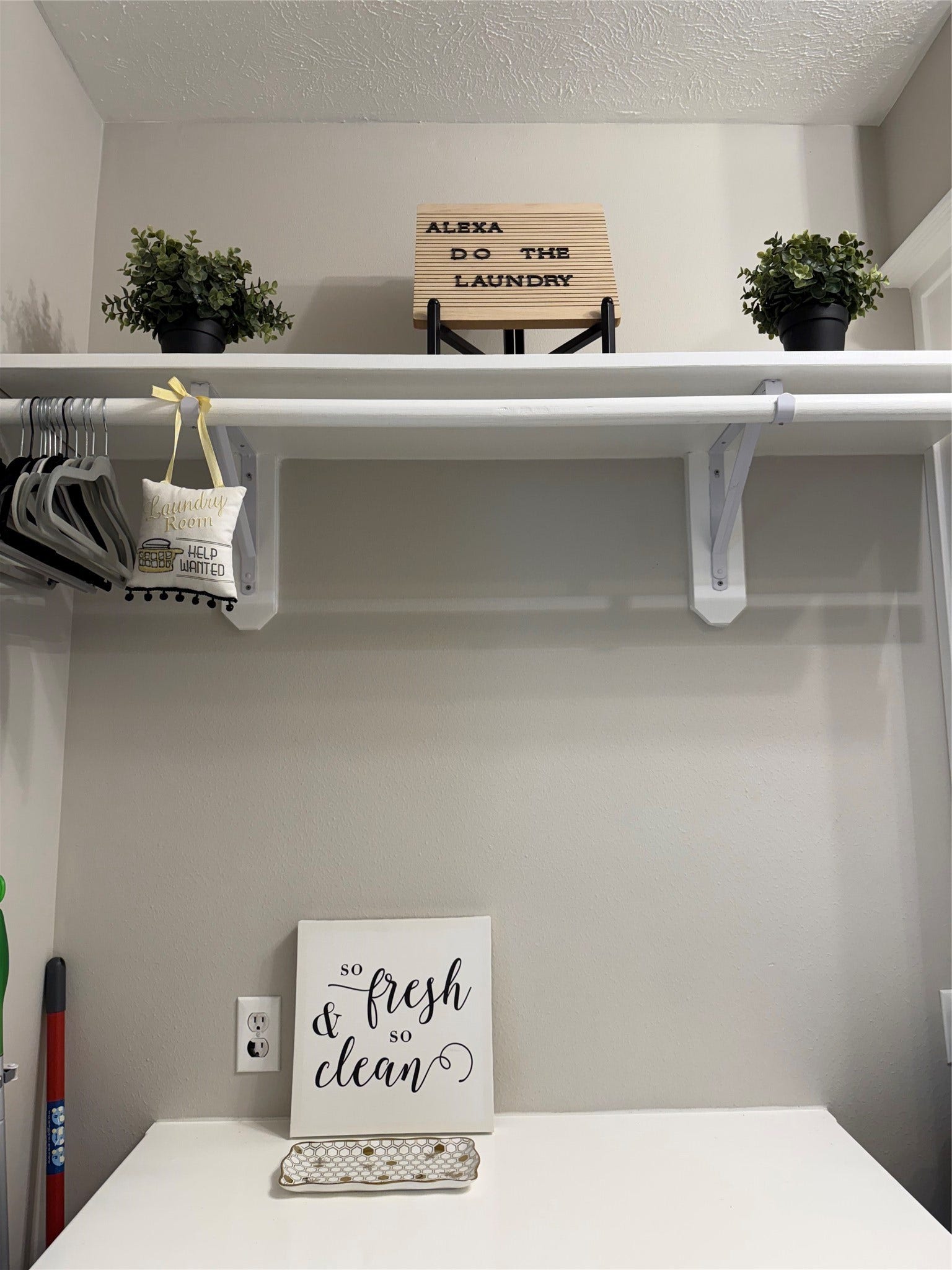 Hanging area in laundry room with additional storage above