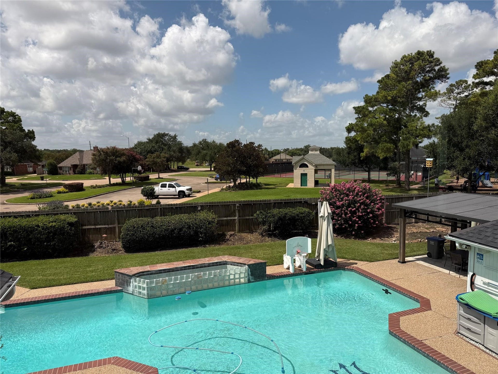 View of the pool, park and tennis court from the game room upstairs