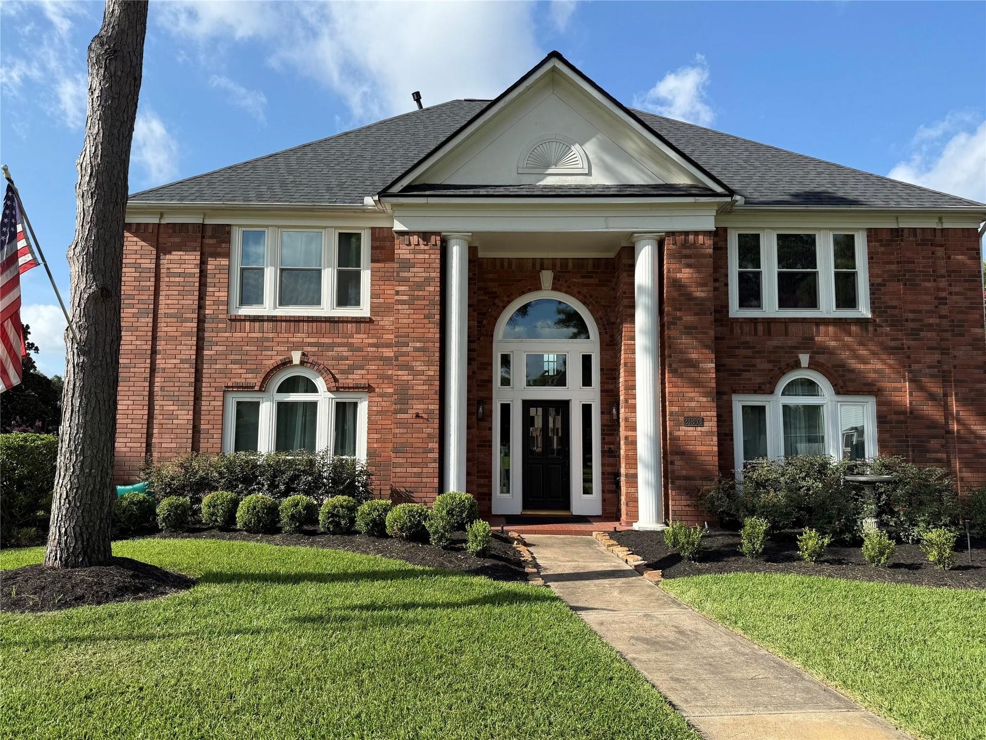 Discover timeless elegance with this stately brick home, nestled among mature trees and lush landscaping, offering charm and tranquility.
