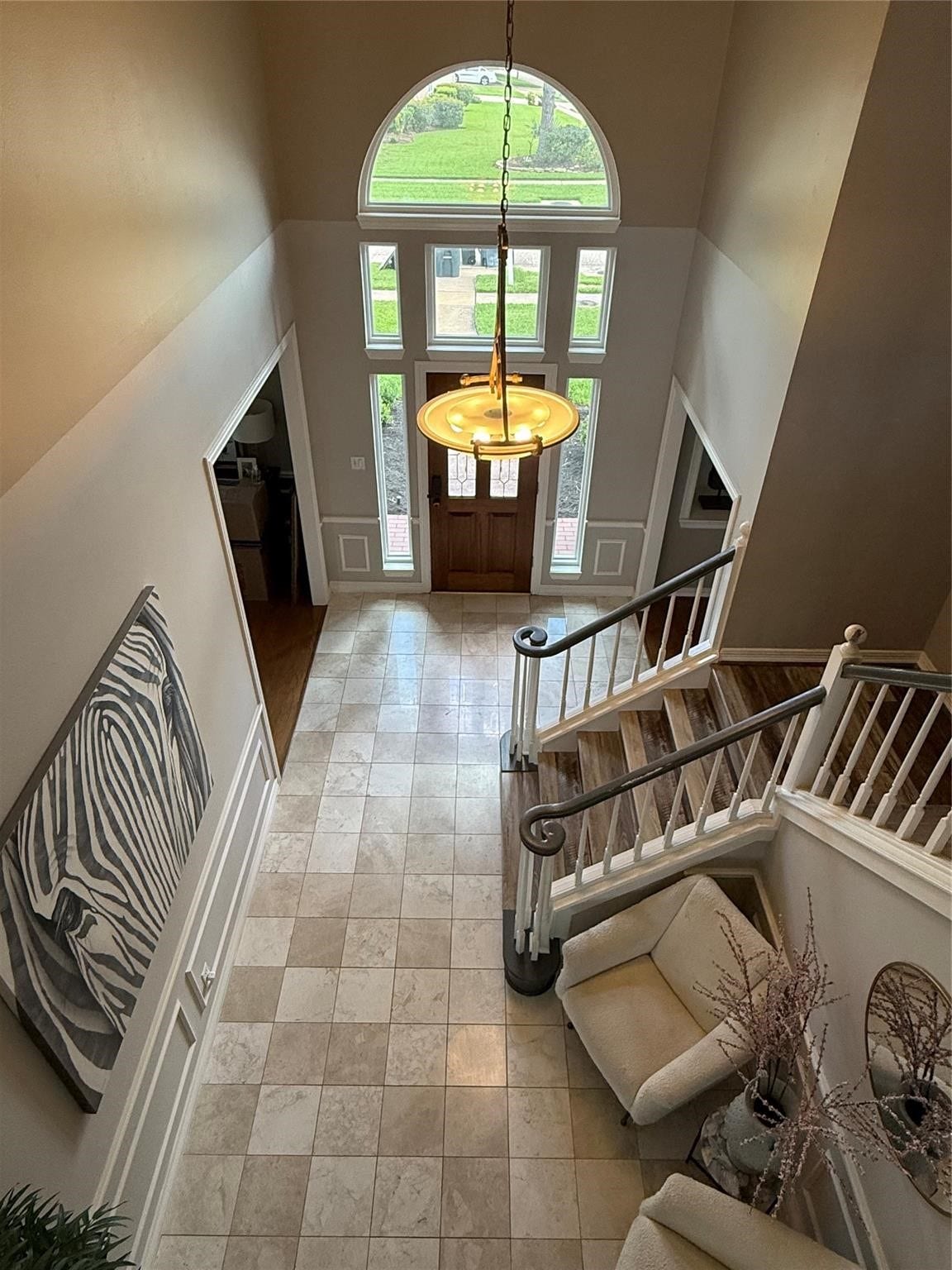 A grand foyer with soaring ceilings and elegant tile flooring welcomes you, leading to a cozy family room featuring a warm gas fireplace.