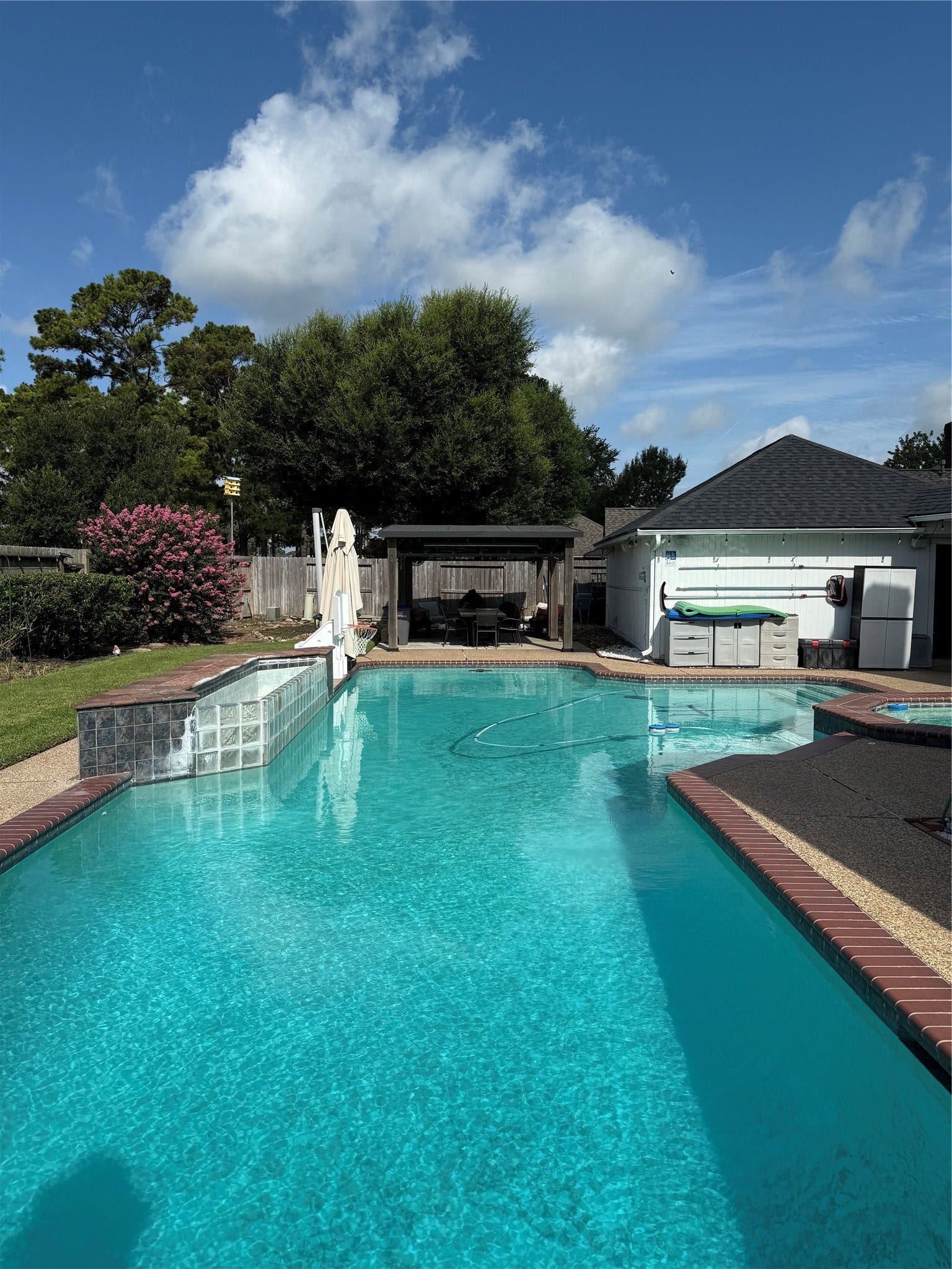 Oversized swimming pool with covered patio area