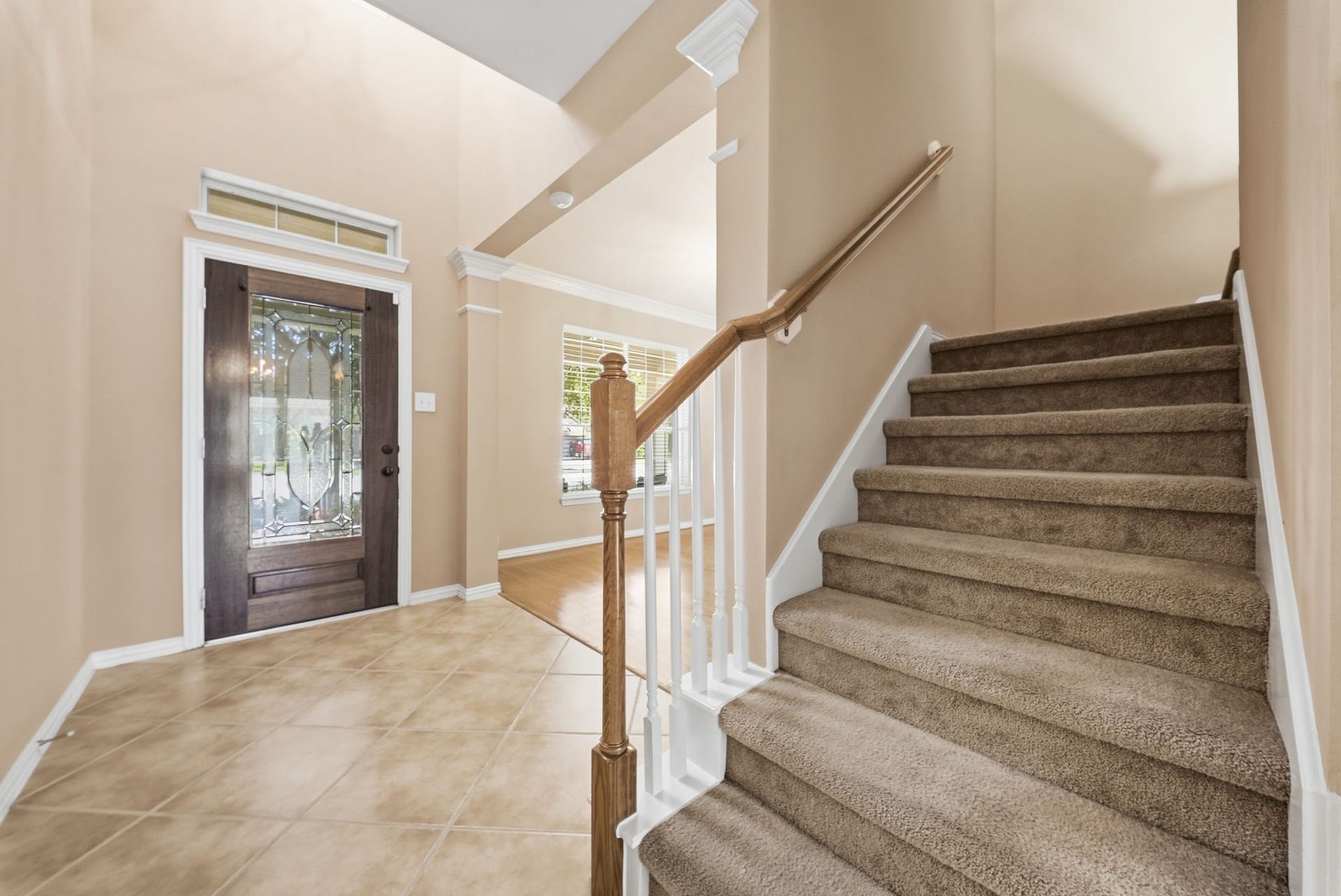 Soaring ceilings create an inviting first impression, with a formal dining area to the left and a staircase leading to the upstairs game room and additional living spaces.