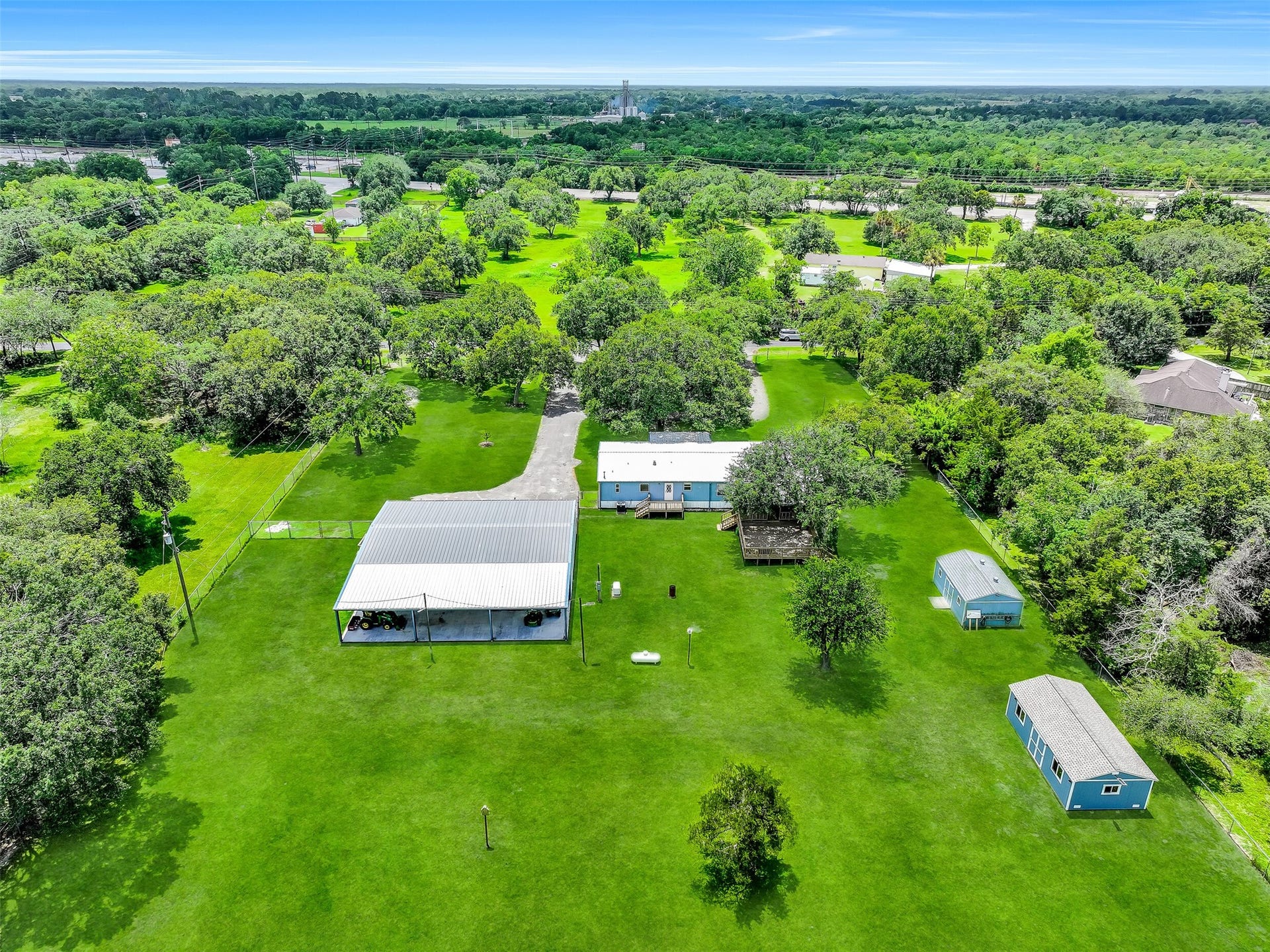 Looking back toward the residence, you'll appreciate how the improvements are thoughtfully nestled beneath a canopy of mature oaks. The long driveway, expansive decking, and generous green space create a welcoming country retreat that feels private from every direction.