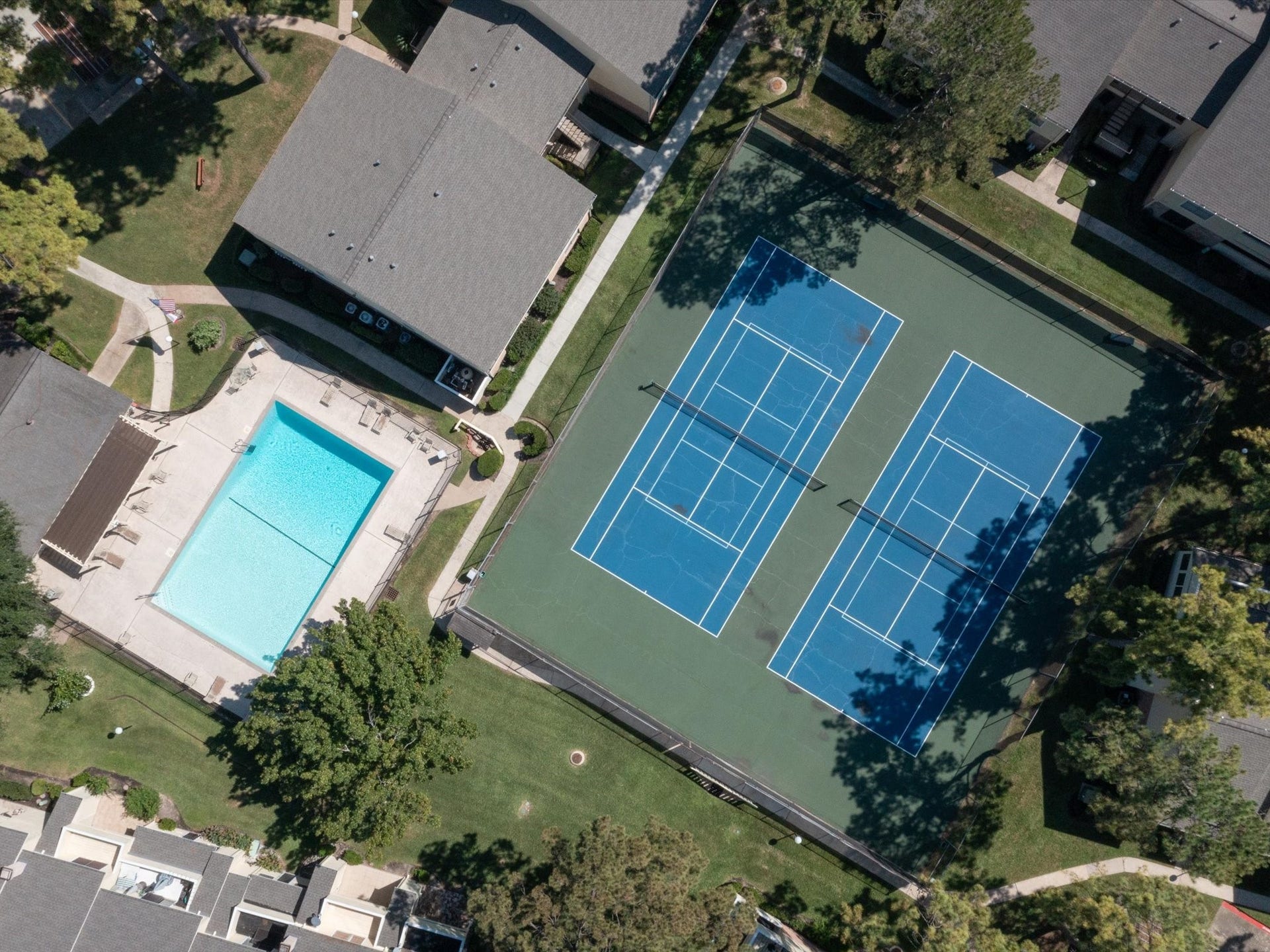 Aerial view showcasing the community swimming pool and tennis courts.